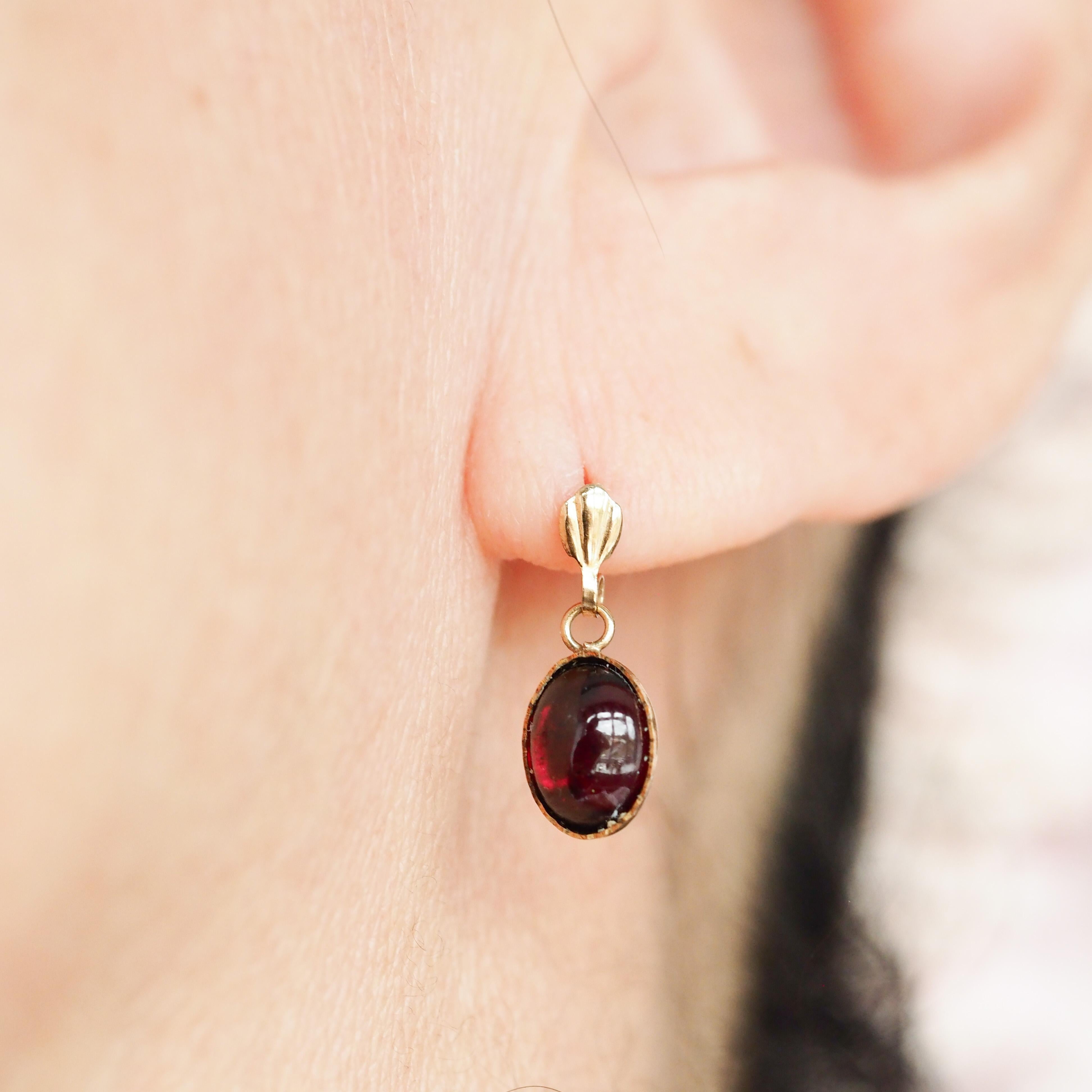 We are delighted to offer this beautiful pair of vintage 9ct gold garnet cabochon earrings.  

Displaying cabochons in their best light, these earrings feature a lovely pair of garnets with a deep reddish pink hue. Owing to its design and the fact