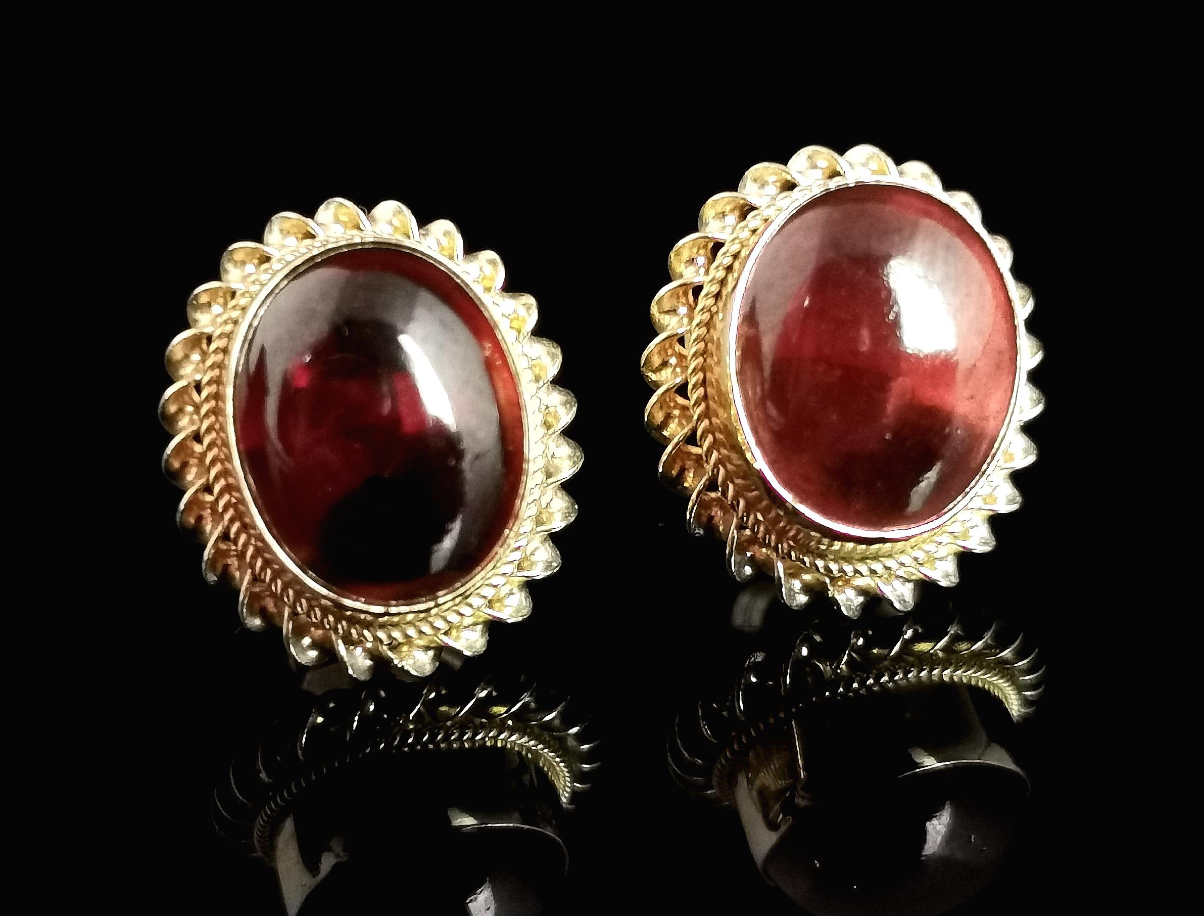 Ein wunderschönes Paar Vintage-Granat-Cabochon-Ohrstecker.

Schöne rote Granat-Cabochons, geschnitzt und hochglanzpoliert, eingefasst in einen hübschen Rahmen aus 9-karätigem Gelbgold mit Rope-Twist-Montage.

Alle sind in 9-karätigem Gelbgold