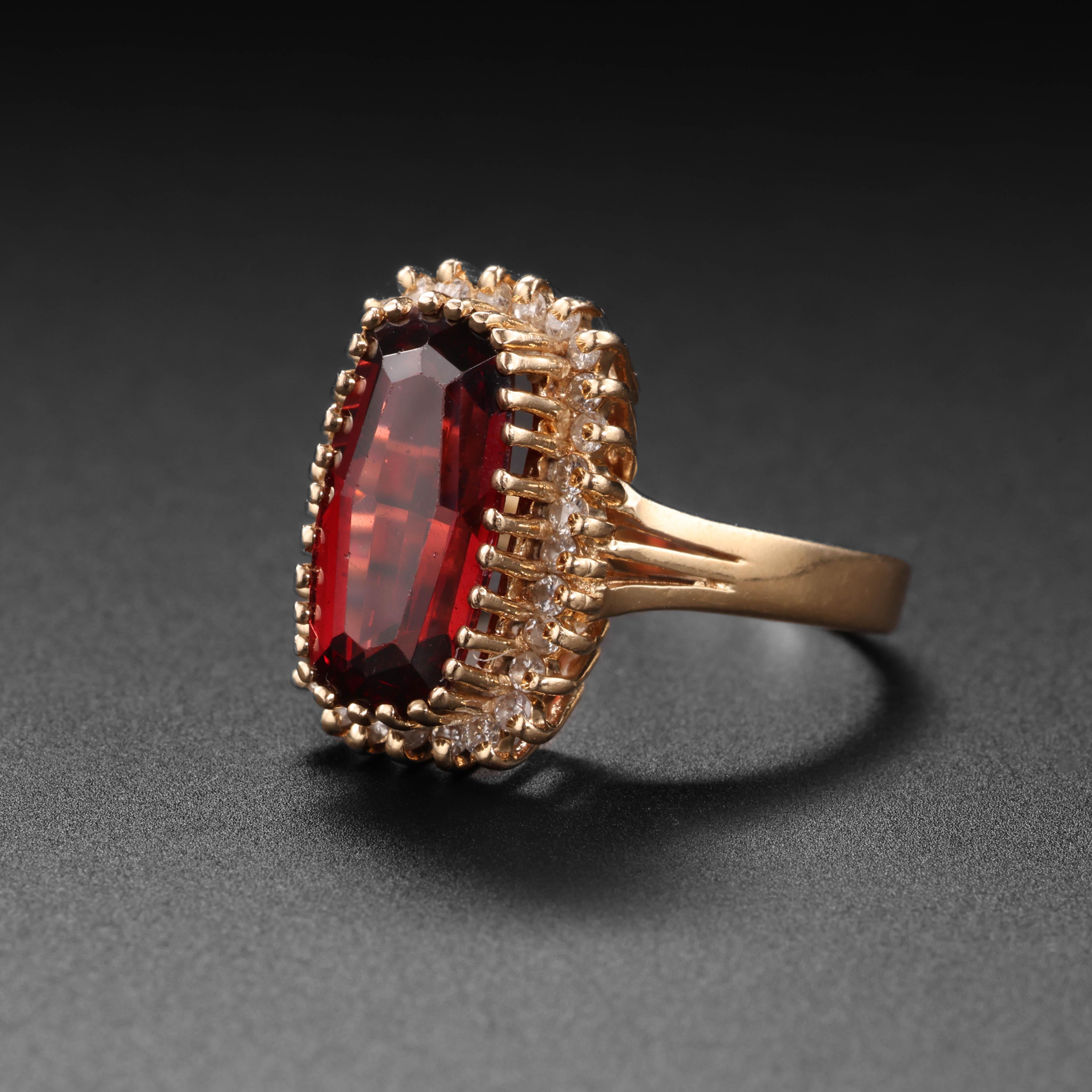 An elongated hexagonal-cut wine-red garnet is surrounded by 30 tiny, sparkling prong-set diamonds in this fancy and fun vintage garnet ring. The garnet measures 11.07 x 6mm and weighs approximately 2.08 carats. The lively red garnet is surrounded by