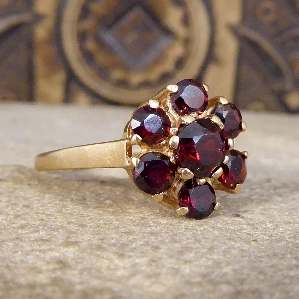So ein schöner Vintage-Ring mit einem größeren Granat-Stein in der Mitte mit 6 einzelnen Granaten, die das Zentrum in einer Blume Cluster-Stil umgeben. Alle Steine sind in 9 Karat Gelbgold gefasst.

Ring Größe: UK O 1/2 oder US 7.25
Zustand: Sehr