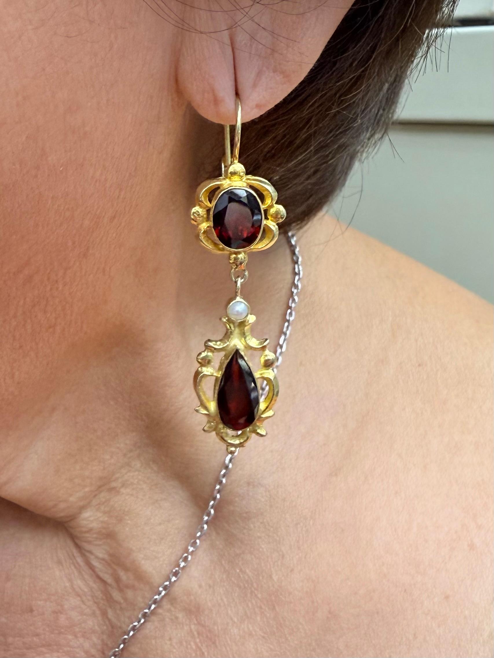  Vintage Garnet and Pearl 14k Yellow Gold Drop Earrings.

The Vintage Garnet and Pearl 14k Yellow Gold Drop Earrings were made in the 1970s.  The Garnets have a rich dark red color that highlight the gold.  And a small pearl in each earring adds a
