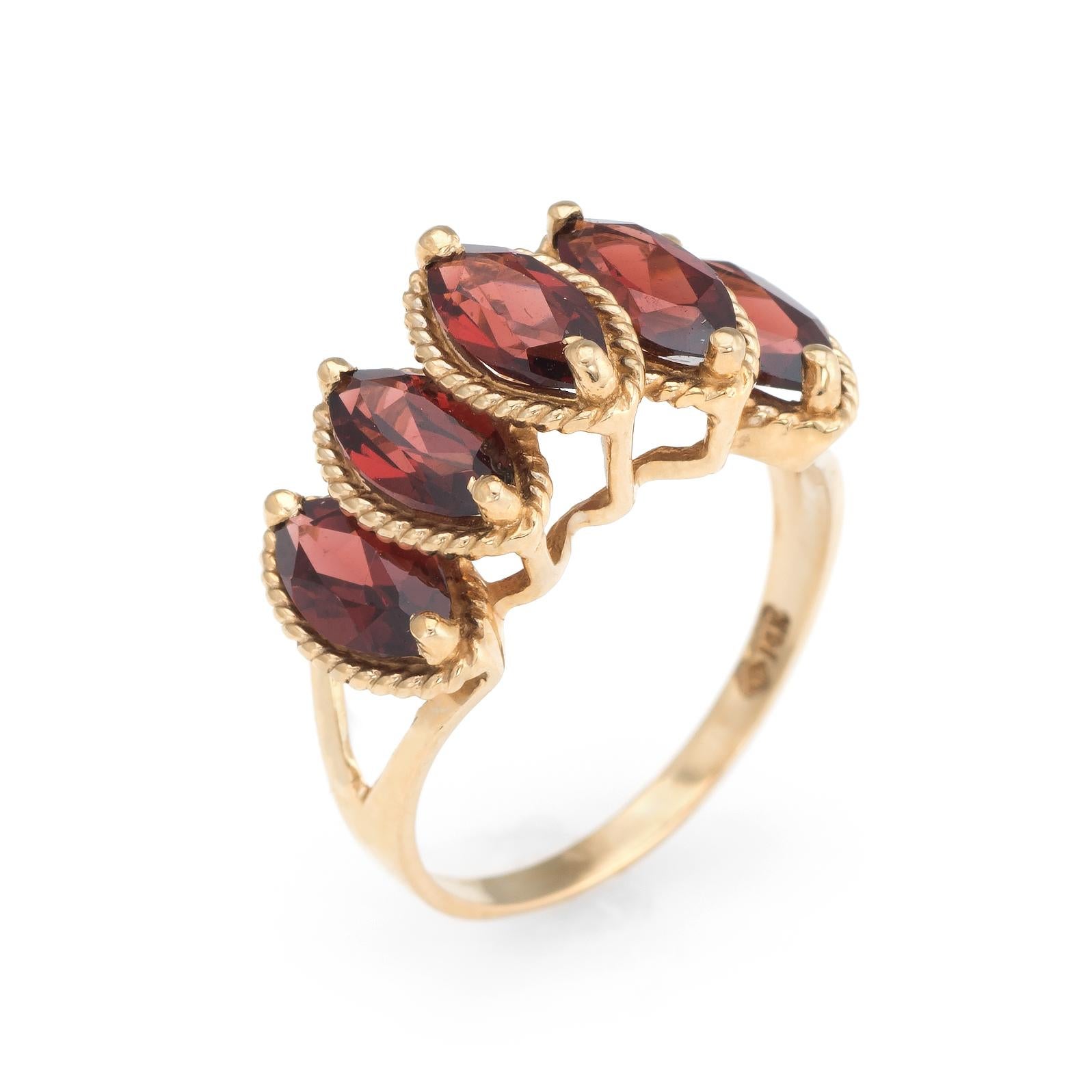Finely detailed vintage garnet ring, crafted in 14 karat yellow gold. 

Marquise cut garnets each measure 8mm x 4mm (estimated 0.57 carats each - 2.85 carats each). The garnets are in excellent condition and free of cracks or chips. 

The rich