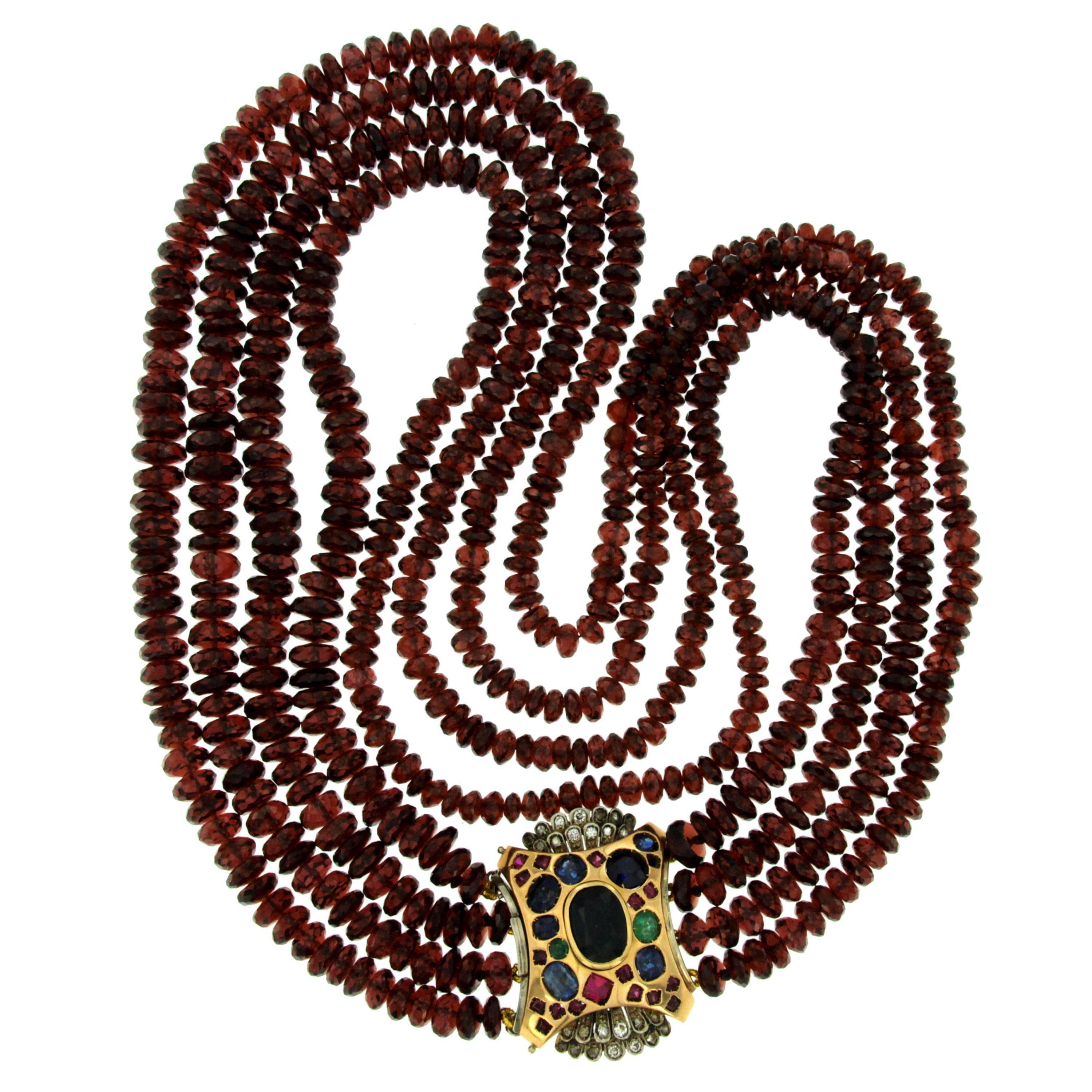 Thus beautiful and unusual necklace features great quality of Natural Garnet. with a precious 18k yellow gold clasp, set with 7 carats of fine colored stones, as Sapphire, Emerald, Ruby and 0,30 of round brilliant diamonds.

Origin Italy