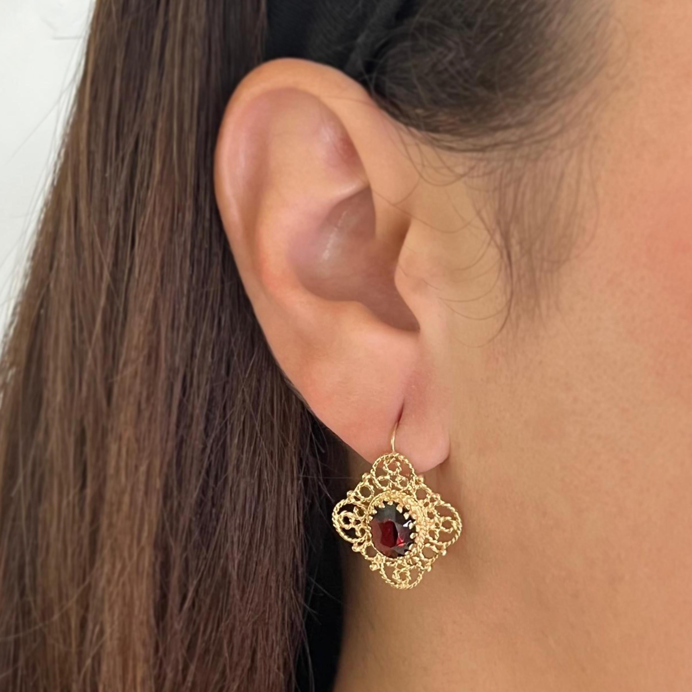 Pendientes colgantes de oro amarillo de 14 quilates con 2 granates de talla oval que suman aproximadamente 3,00 quilates. Longitud de 2,5 cm con cierre de alambre y gancho. El peso final es de 4,8 gramos.