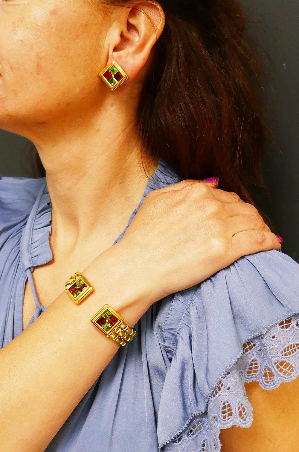  	A gorgeous Garrard 18 karat gold and gemstones vintage set consisting of a cuff bracelet and earrings. 
        The set design is inspired by architectural motifs. The cuff is crafted out of the beveled gold “bricks” and resembles a wall. The