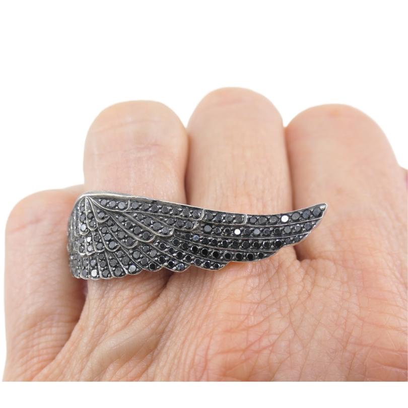 A dramatic Garrard black diamond Wing ring crafted of 18k gold.
The ring features a sculptural design inspired by the elegance of feathers. Each individual feather segment is outlined with black diamonds that follow the contours of the design. The