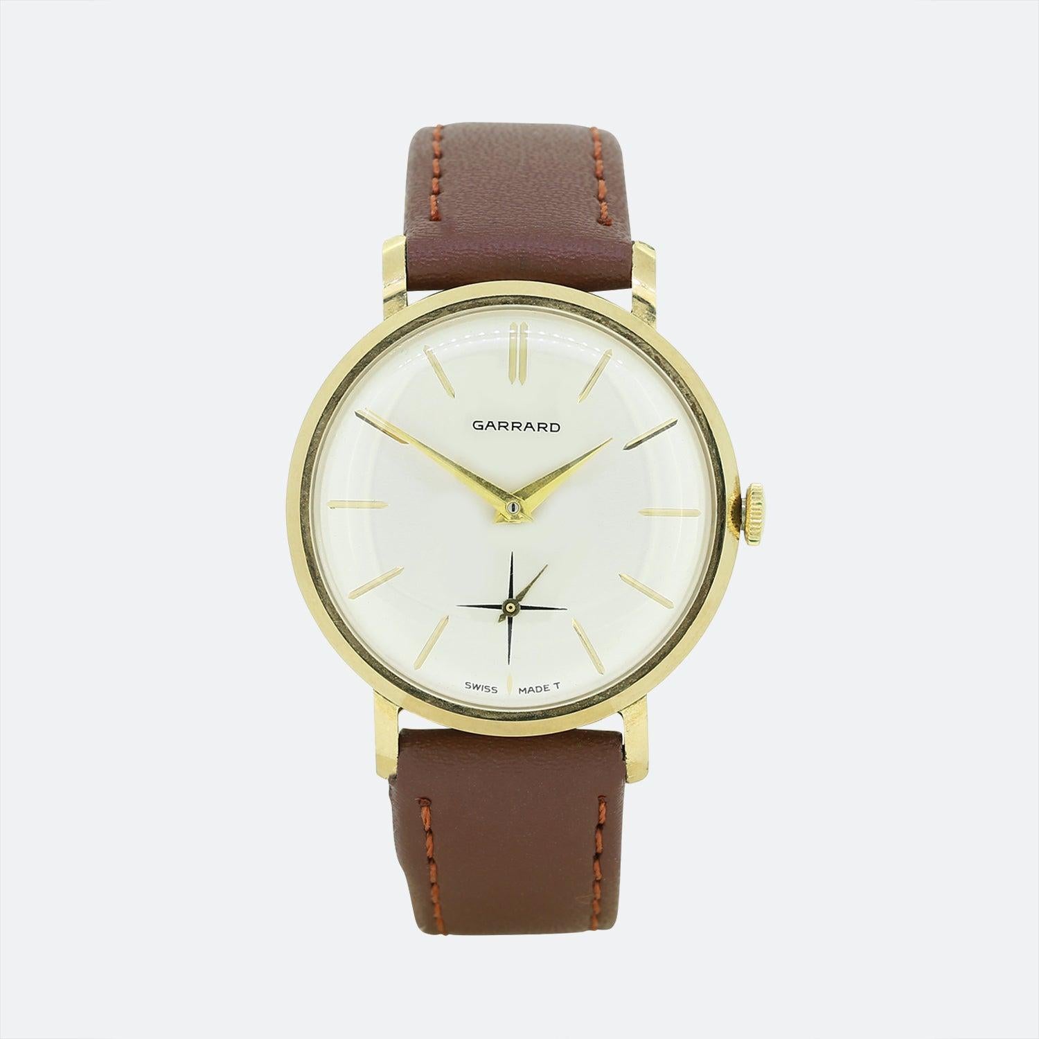 Dies ist eine entzückende Vintage-Armbanduhr des Luxusschmuckdesigners Garrard. Die Uhr hat ein rundes Zifferblatt mit silberfarbenem Zifferblatt, goldenen Stundenmarkierungen und goldenen Zeigern. Außerdem verfügt sie über ein Sekundenzifferblatt