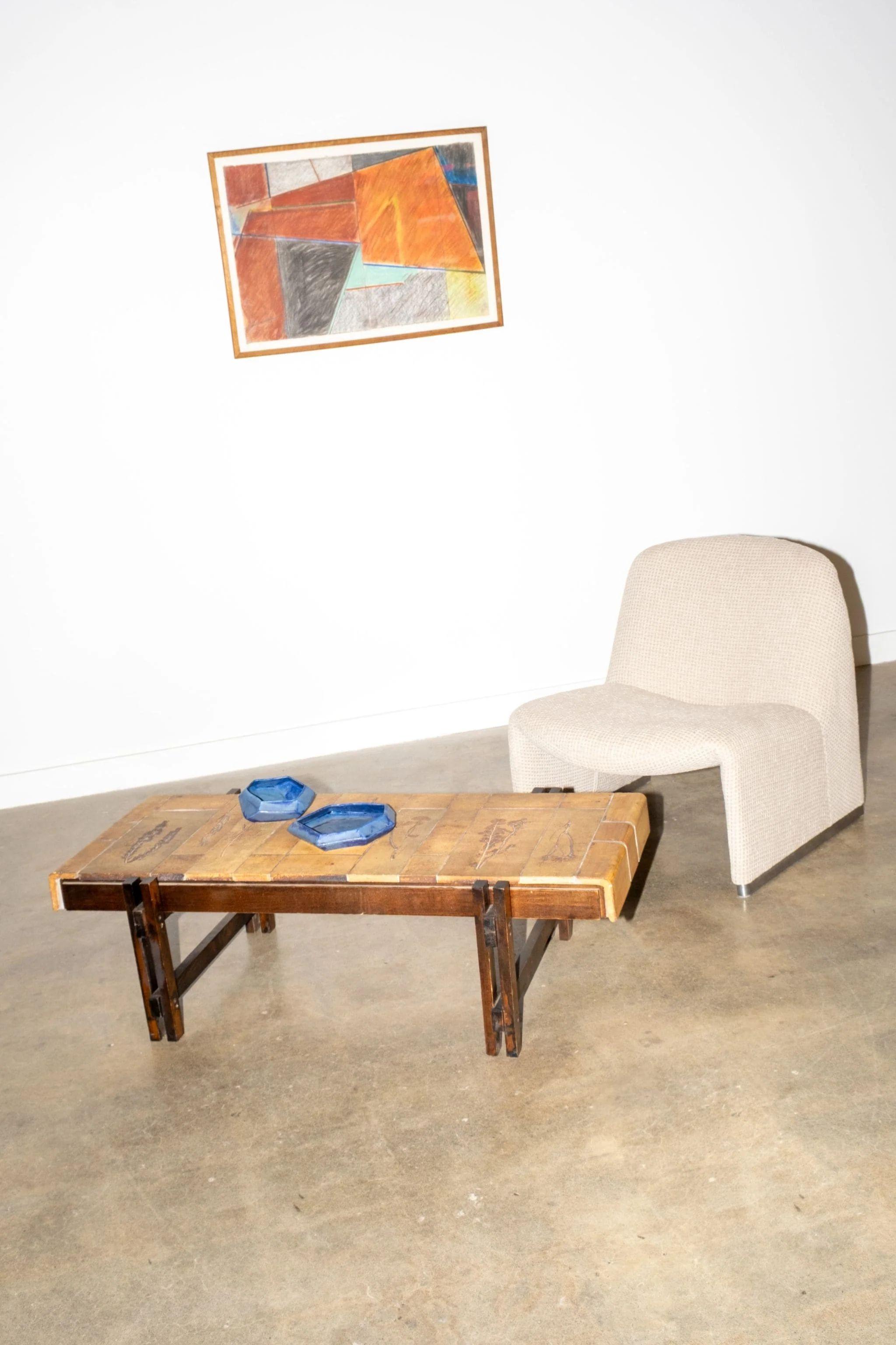 Évoquant les après-midi ensoleillés du sud de la France, cette table basse Garrigue présente un plateau en céramique gravé d'une délicate flore pressée. Conçue par Roger Capron dans les années 1960, chaque tuile contient de vraies plantes cueillies