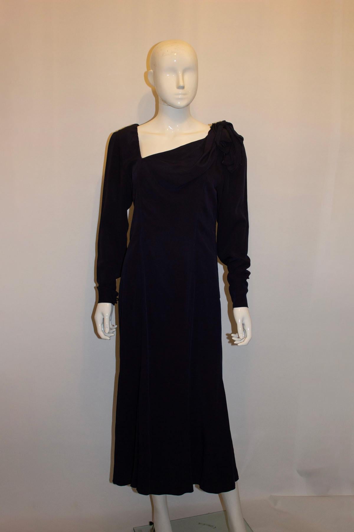 Une robe de soirée vintage du créateur français Gaston Jaunet qui fait tourner les têtes. D'un bleu profond, la robe présente une encolure intéressante avec des détails sur une épaule, une ouverture zippée sur le côté et des poignets