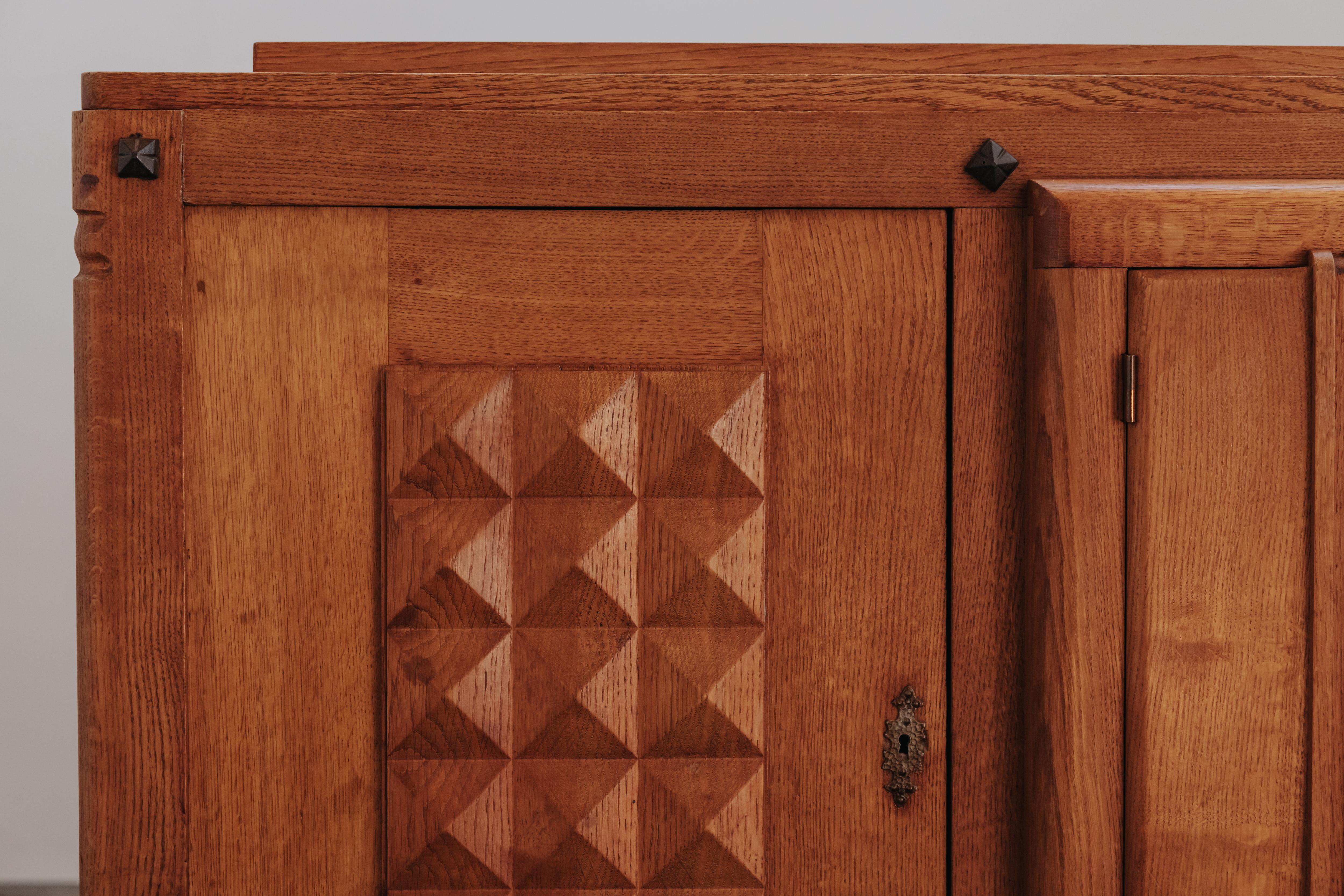 Credenza vintage Gaston Poisson dalla Francia, circa 1960.  Struttura in rovere massiccio con dettagli in ottone.  Modello raro con usura e uso molto leggeri.