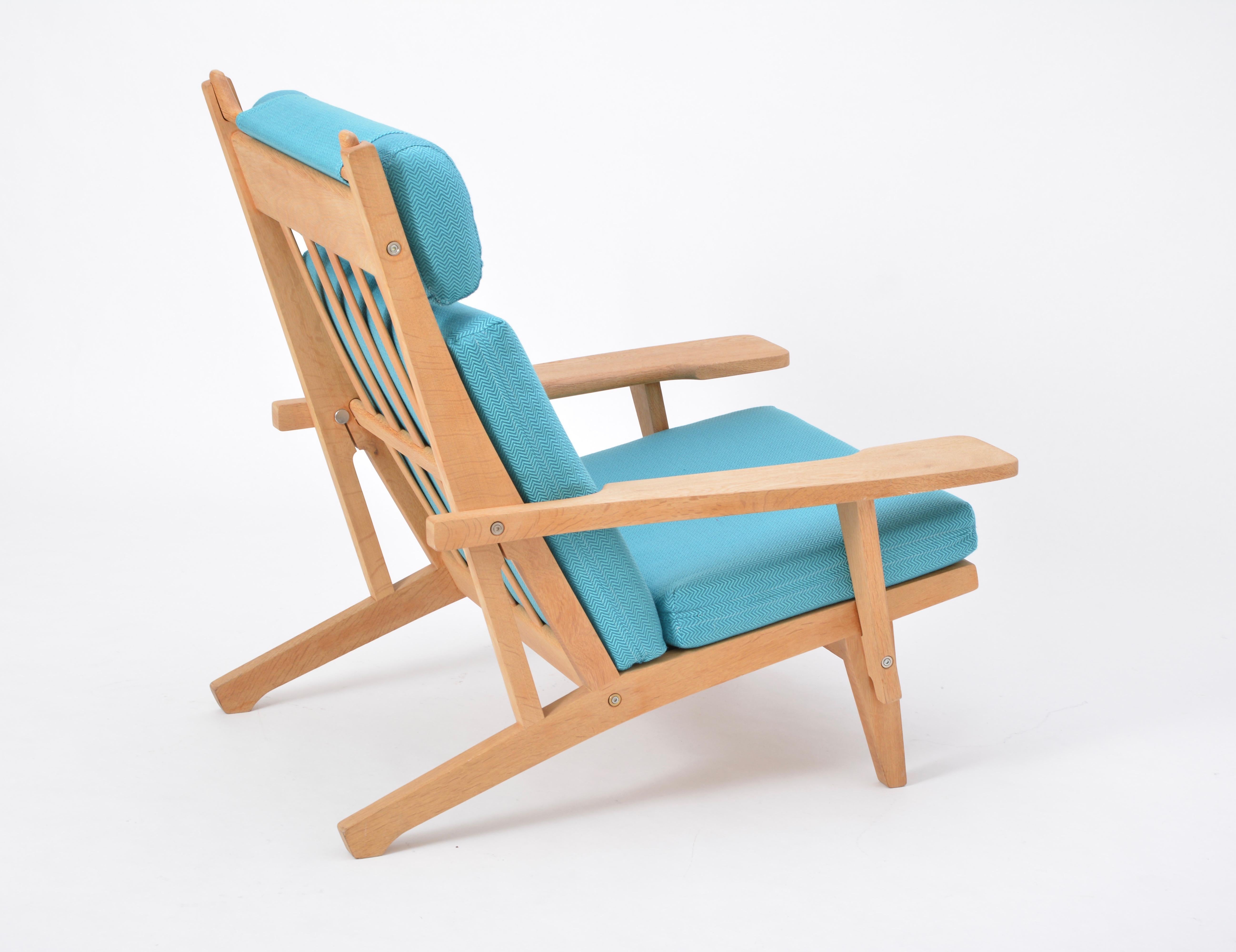 Turquoise Mid-Century Modern GE 375 Easy Chair by Hans J. Wegner for GETAMA 

This easy chair is a version of the GE 375 model with armrests and a high backrest that Hans J. Wegner designed for GETAMA in 1969. The frame is made from oak; the loose