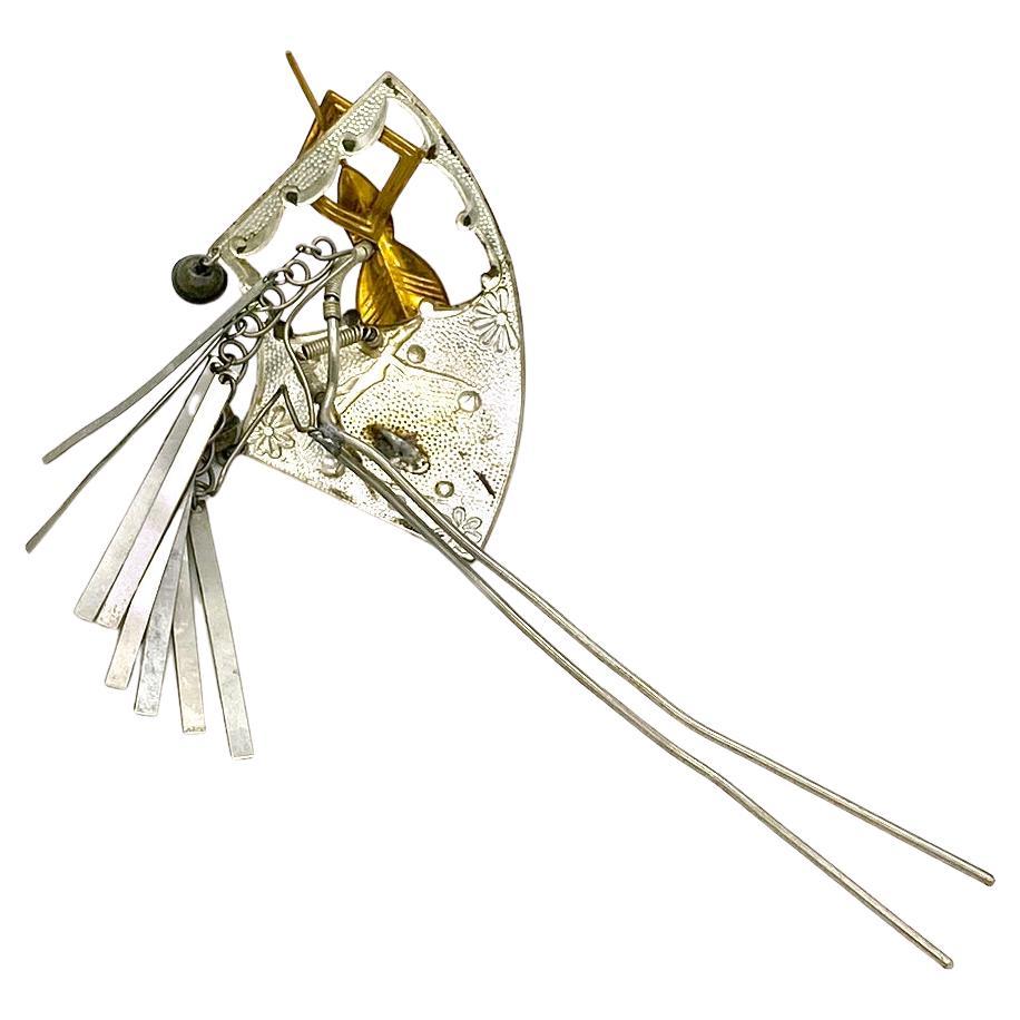This is a vintage geisha hair ornament. This fan shaped  hair comb is open on one side with a textured background and multicolor enamel & gilded raised plum flowers and leaves. It trembles on a spring. Another arrow shaped trembler comes through the