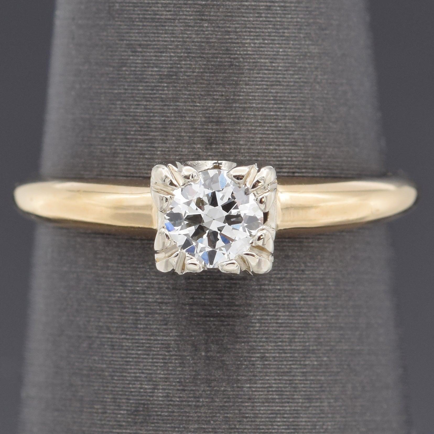 This classic engagement ring features a sparkling round diamond set in a refined white gold head, allowing the stone to shine with brilliance. The polished yellow gold band provides a warm contrast, highlighting the elegance of the two-tone design.