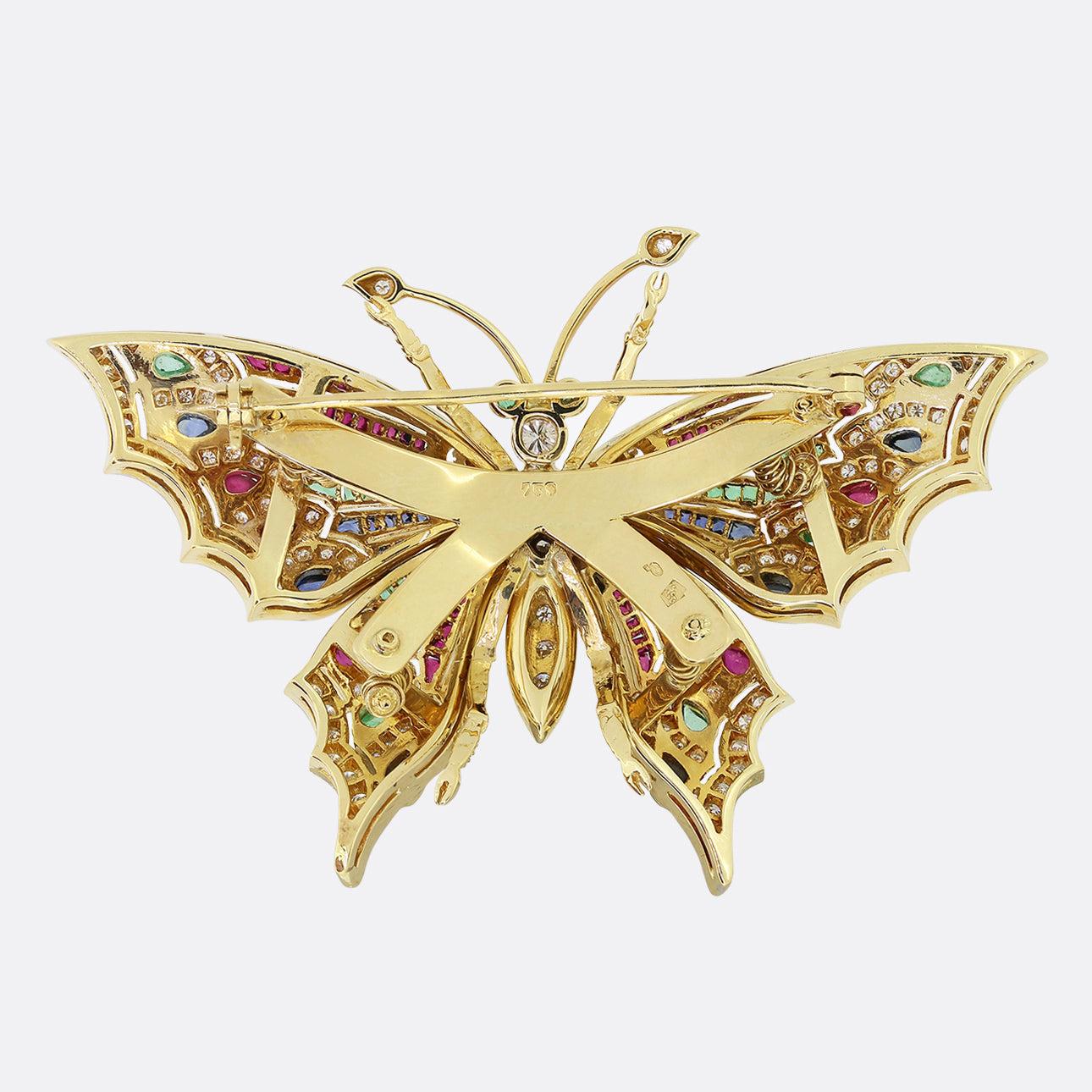 Here we have a vibrant gem set brooch from the 1970s. This vintage piece has been crafted from 18ct yellow gold into the shape of a butterfly with distinct channels milgrain set with a vast array of colourful gemstones of different shapes and sizes
