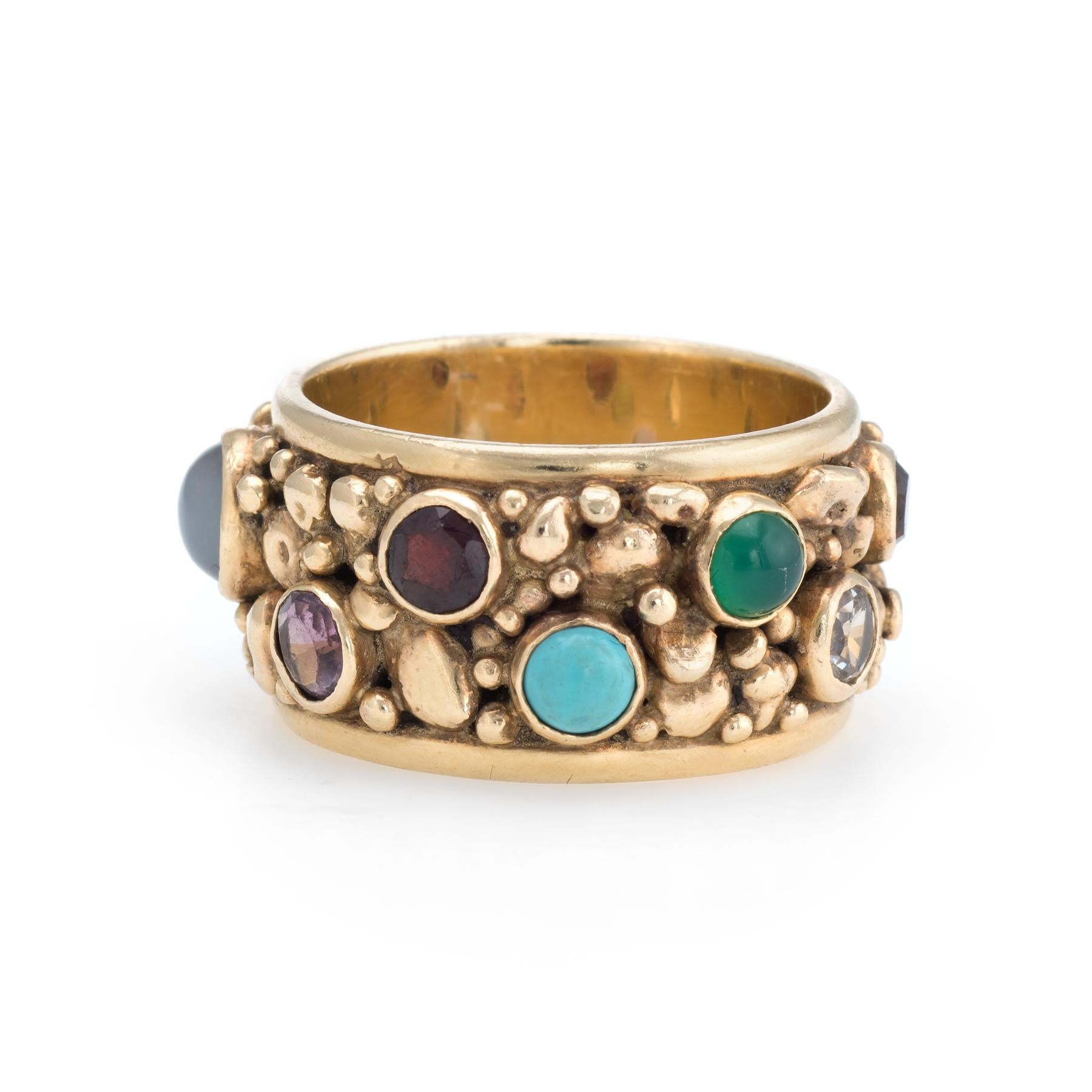 Distinct and unusual vintage gemstone eternity ring (circa 1960s to 1970s), crafted in 14 karat yellow gold. 

The band is set with various gemstones including: moonstone, turquoise, garnet, amethyst, jade, chrysoprase, peridot, cultured pearl and