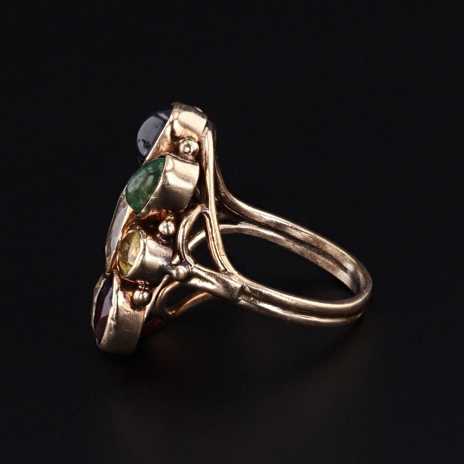 This vintage ring (circa 1960-1970) features assorted gemstones in 14k gold.

The gemstones include garnet, zircon, emerald, sapphire, aquamarine, and chrysoberyl.

The face of the ring measures 0.9 inches by 0.8 inches wide and is in very good