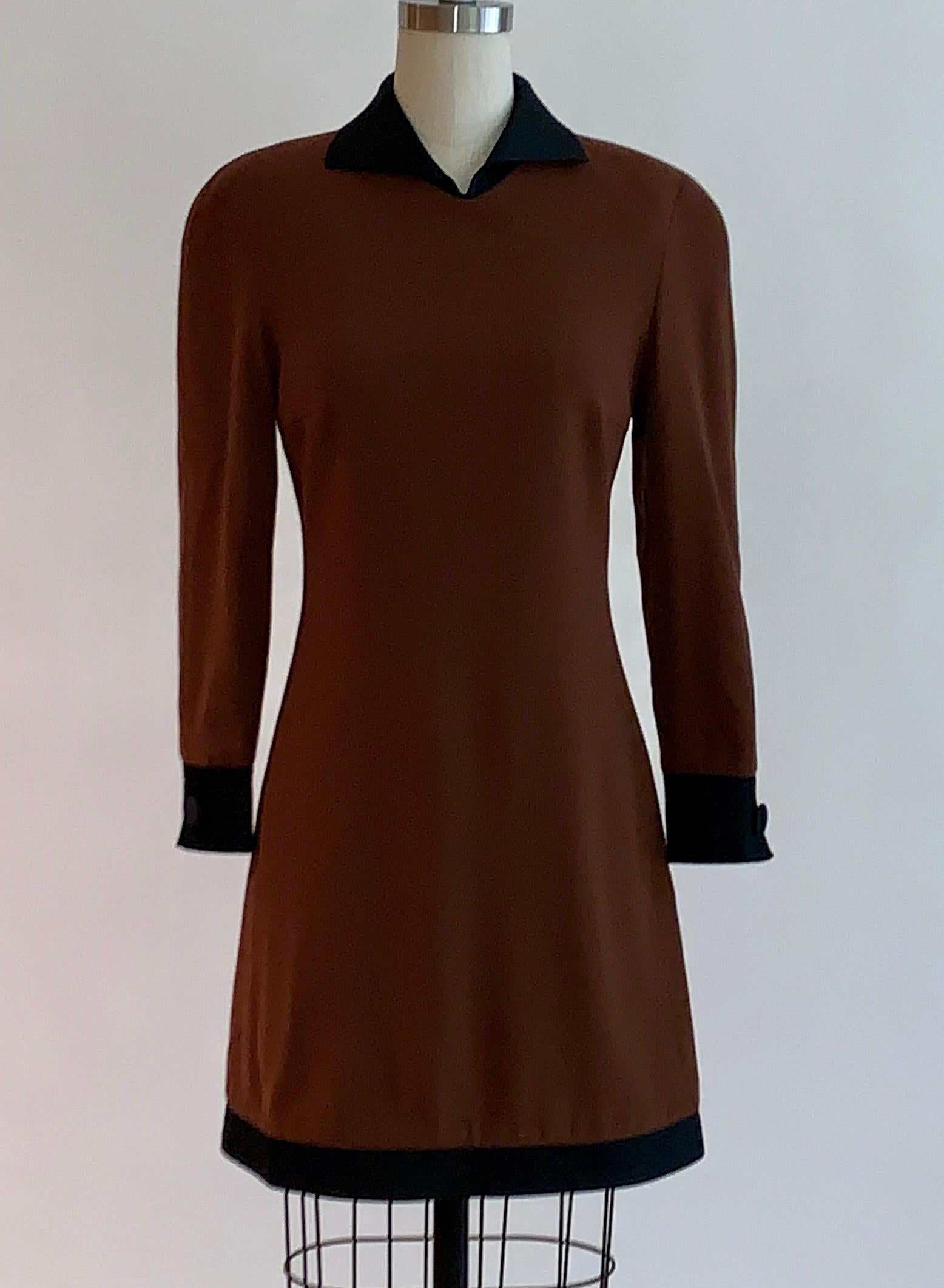 Vintage Genny brown long sleeve mini dress with black satiny quilted trim at collar, cuffs, and hem. Decorative cloth covered buttons at each cuff.  (Unknown decade, estimating 1980s. Possibly from Gianni Versace's tenure as Genny's designer.)