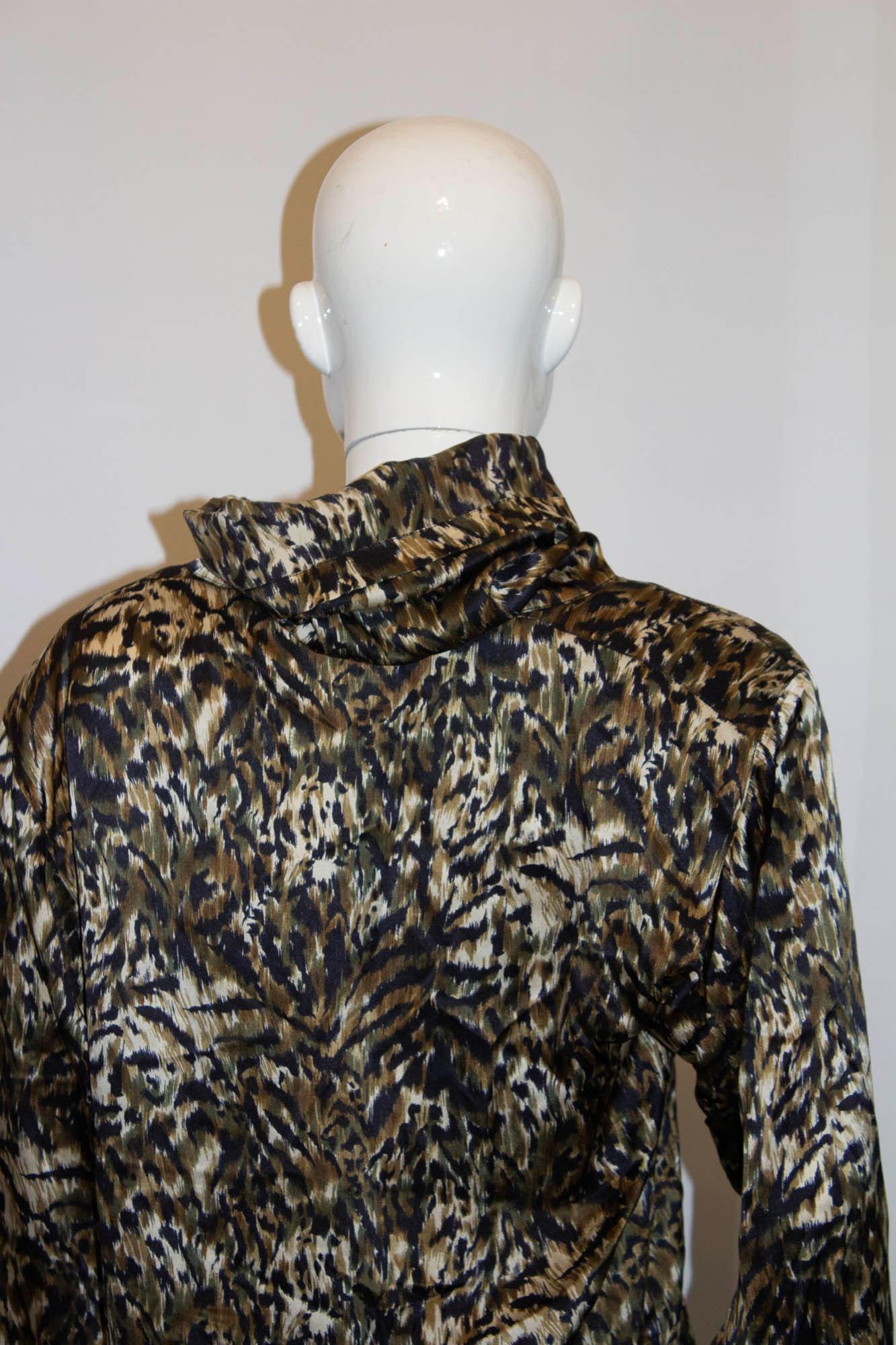A chic vintage silk blouse by Genny. In an olive green, black and khaki mix, it has 4 '' slits on either side, and a cowl neck. Best worn loose fitting. Measurements: Bust up to 42'', length 24''