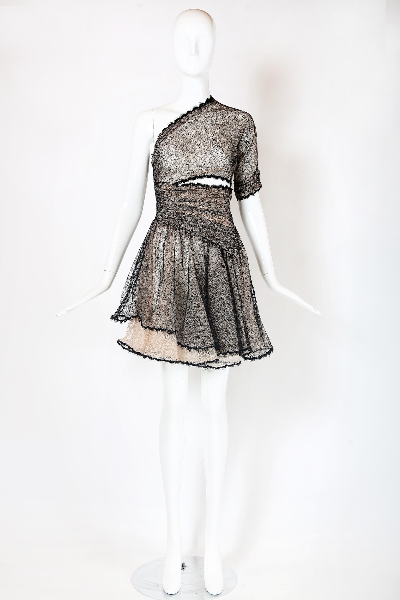 Vintage Geoffrey Beene single shoulder mini dress comprised of a layer of black metallic cobweb lace over a layer of pale pink cobweb lace, a full flouncy skirt and a cutout at the waistline. Zippers up the right side seam. In excellent condition