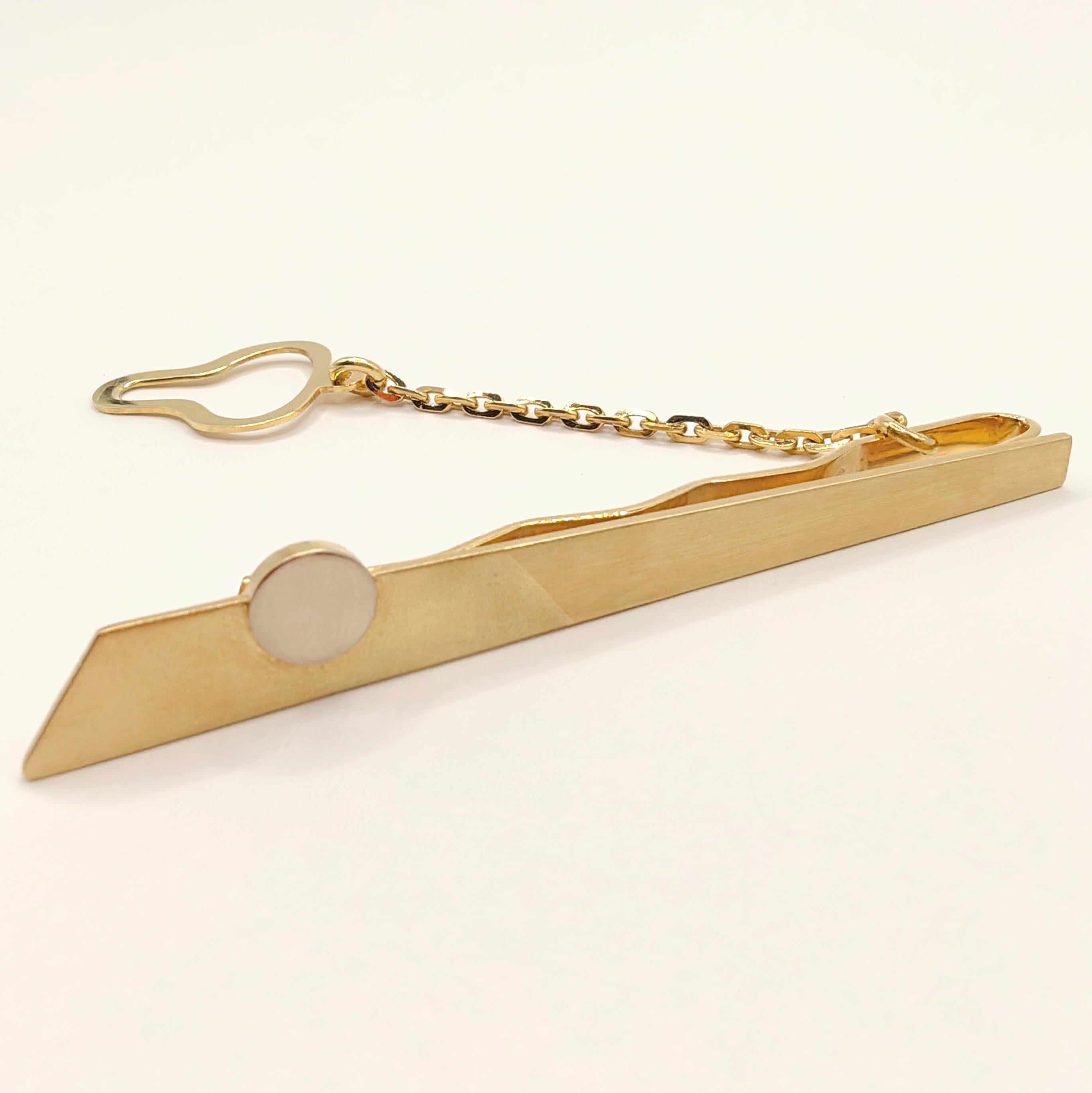 Introducing the Vintage Geometric Design Tie Clip With Chain in 18K Yellow & White Two-tone Gold. This elegant accessory combines sleek geometrical shapes with a sophisticated two-tone gold design, making it a perfect addition to your formal