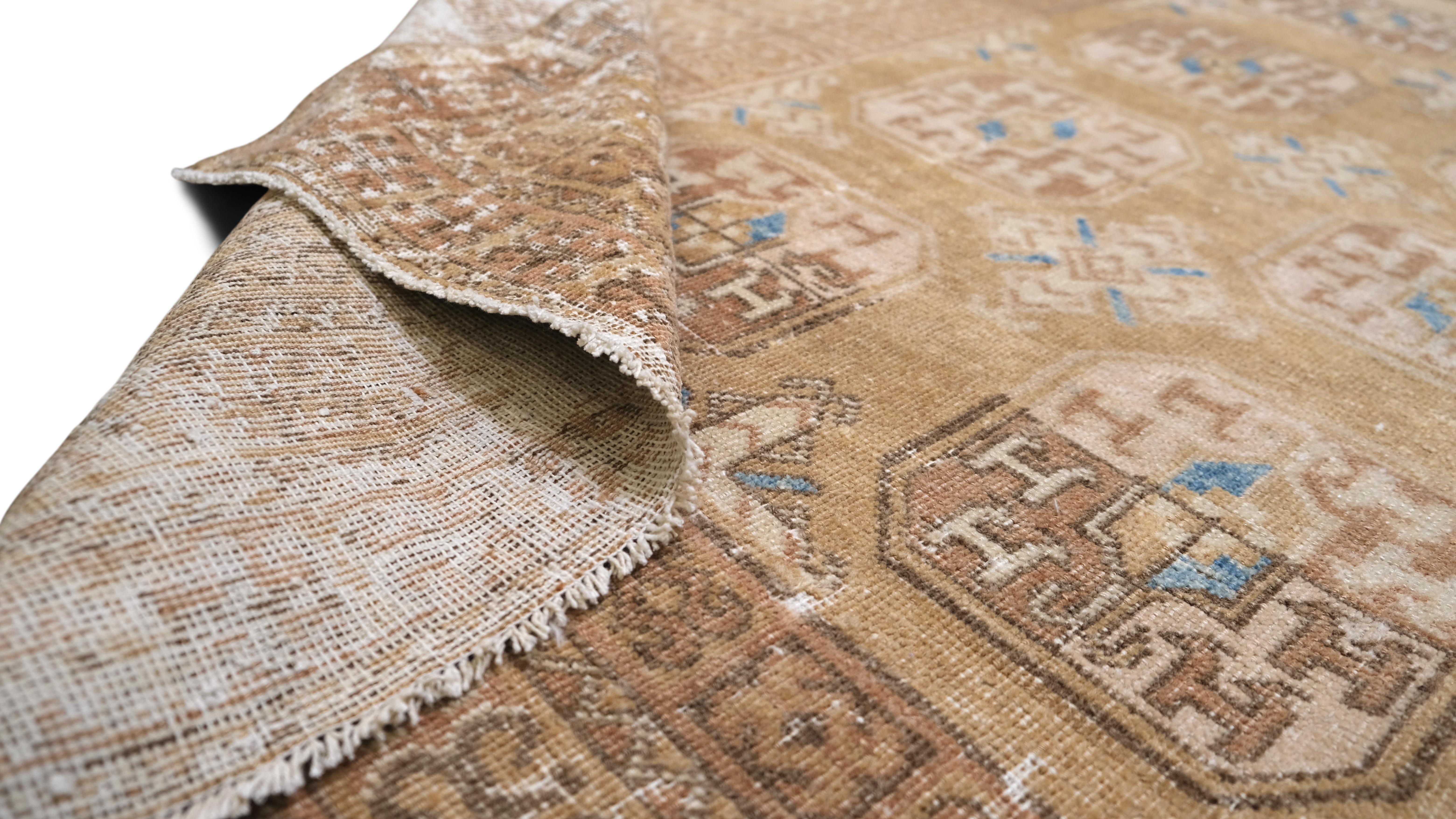 Eleva tu decoración interior con la belleza atemporal de esta alfombra antigua de lana anudada a mano. Hecha a mano por expertos, esta alfombra muestra un diseño tribal geométrico clásico, con medallones que se repiten en una paleta cálida y terrosa