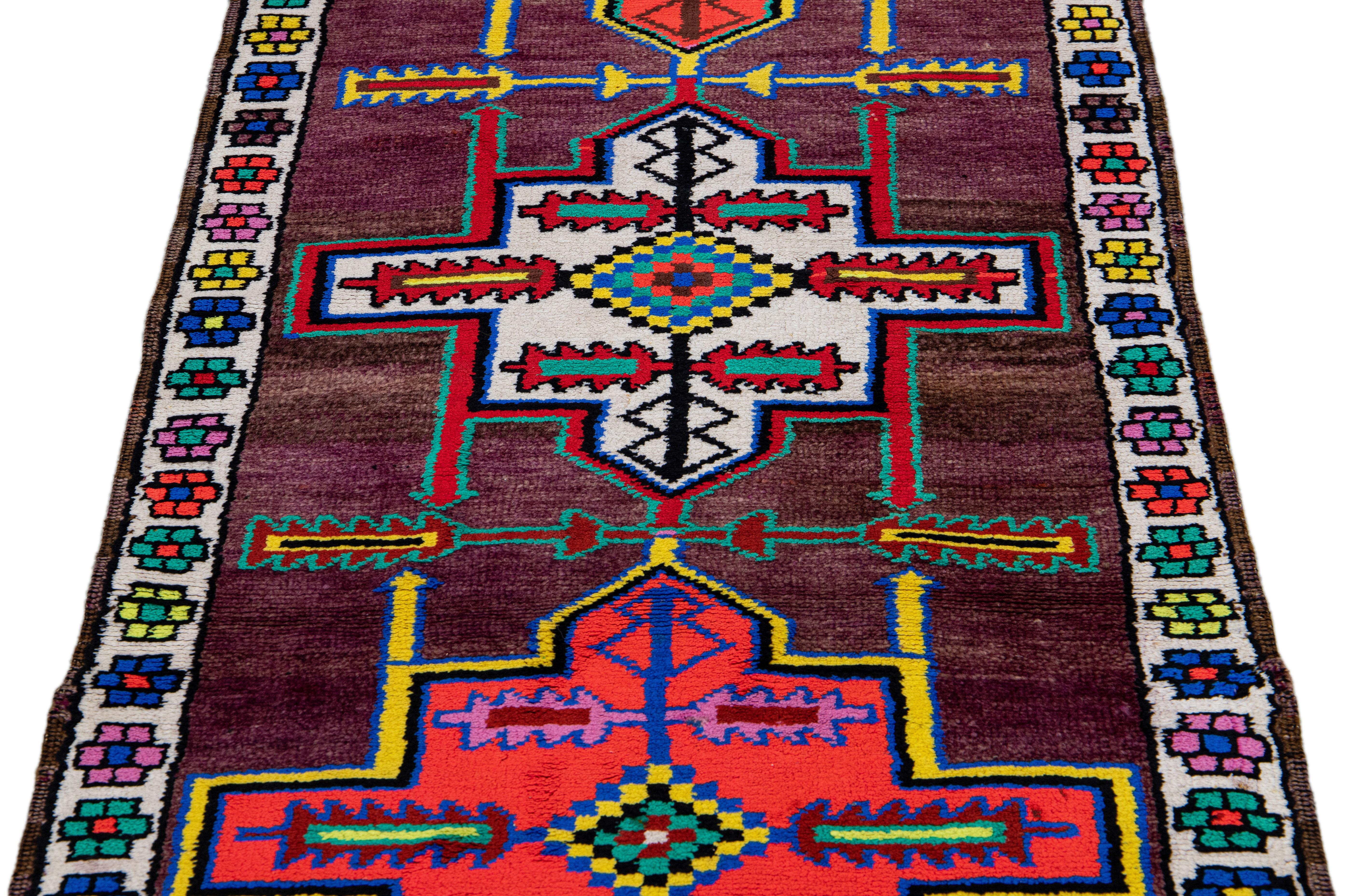 Beautiful vintage Turkish hand-knotted wool rug with a purple field. This rug has a white designed frame and multicolor accents in a gorgeous all-over geometric tribal design.

This rug measures: 2'10