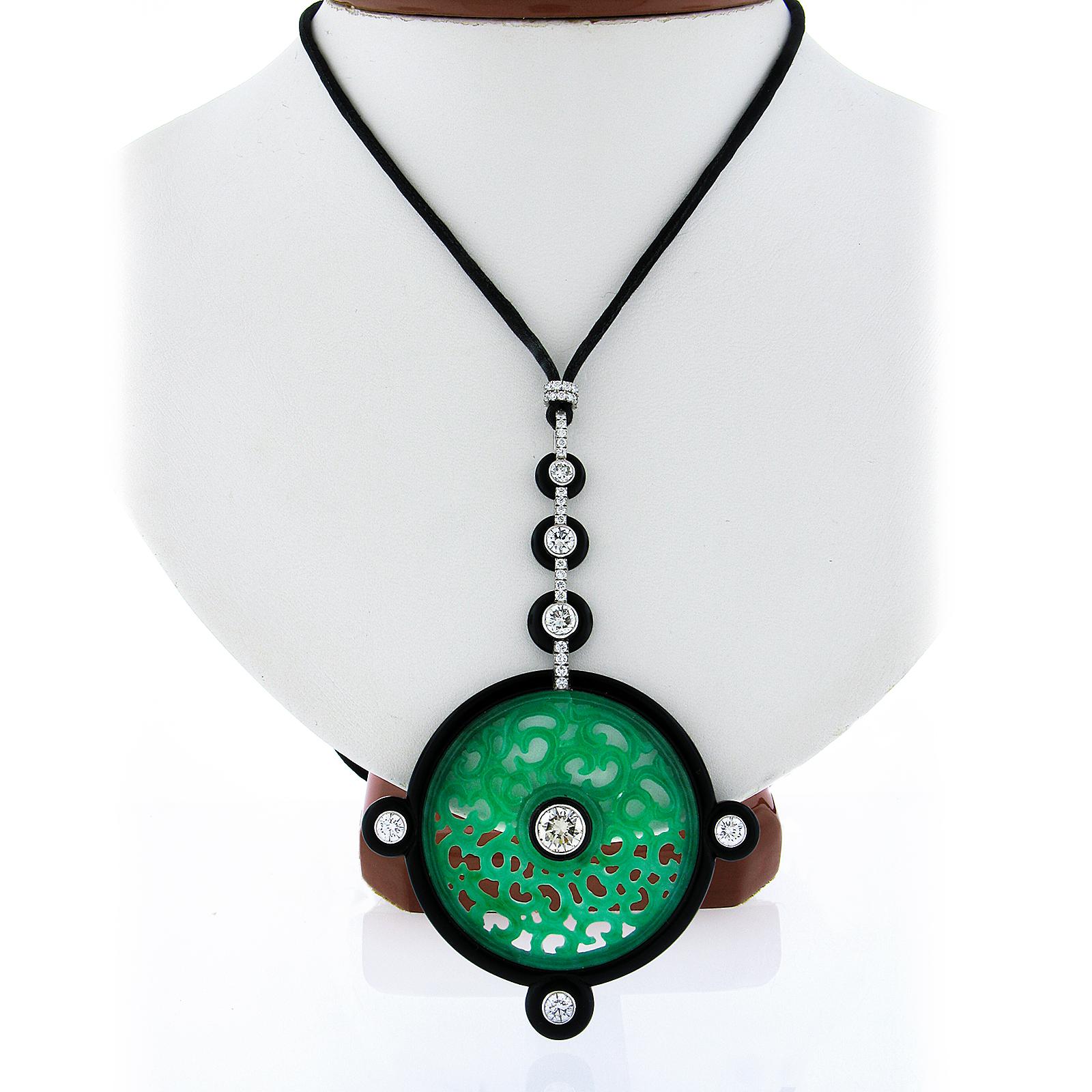 This incredible statement piece by Georg Hornemann is set with a large jadeite jade stone that is pierced and carved throughout and set at the center of a black onyx custom made frame that is further adorned with round brilliant cut diamond