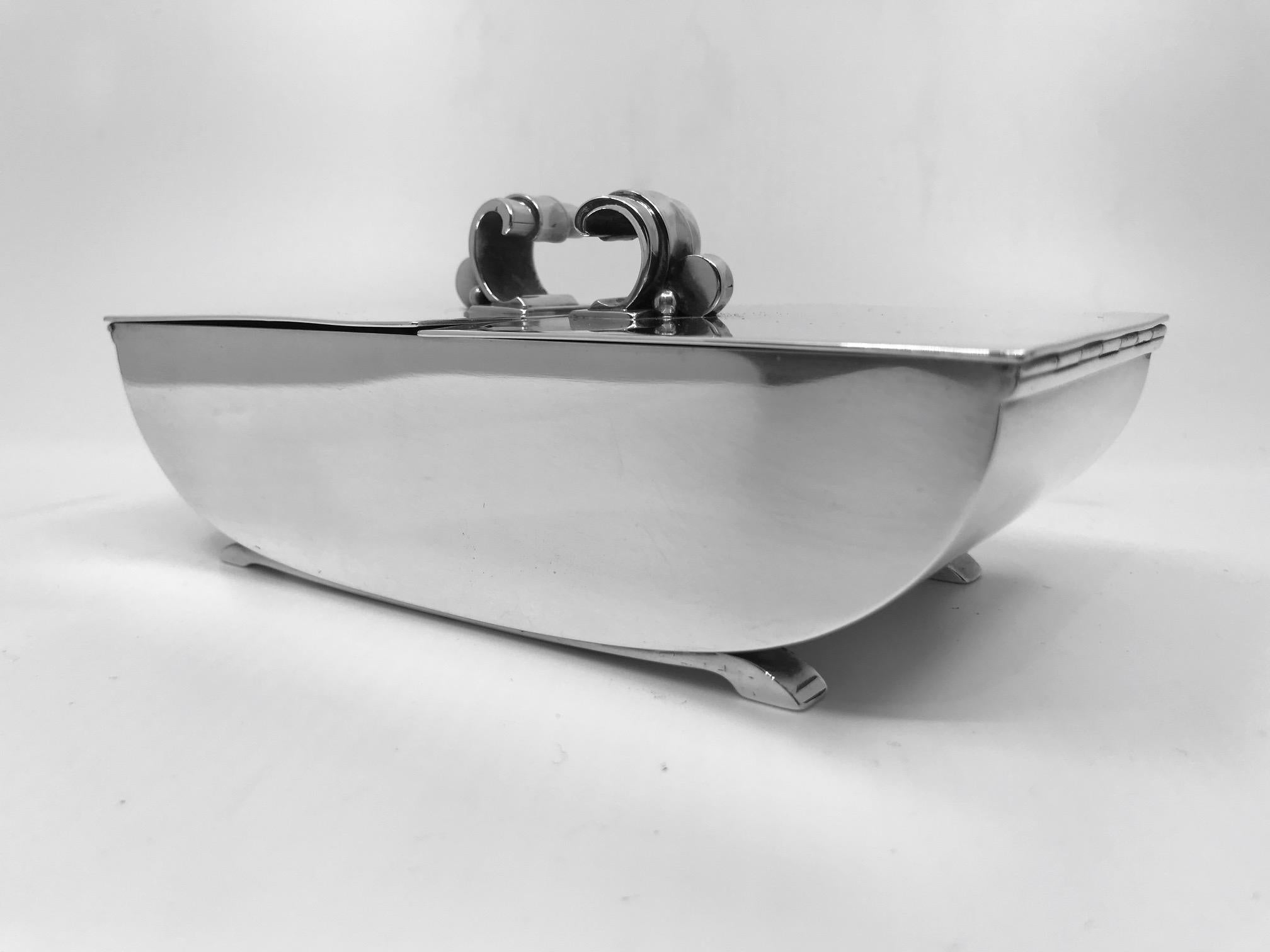 Vintage sterling silver Georg Jensen Art Deco Box, design #833 by Harald Nielsen. The box is divided into two sections with a separate lid for each side, hinged at each end. The divider is removable for larger items.

Measures 6 7/8? x 3 1/8? and