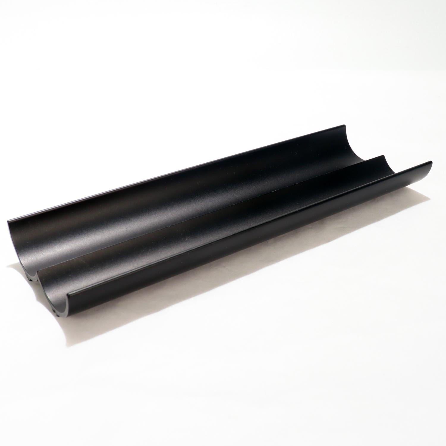 Una buena bandeja para bolígrafos u organizador de escritorio.

Por Georg Jensen.

En metal recubierto de polvo negro (suponemos que aluminio).

En forma de bandeja rectangular con 2 secciones festoneadas.

Marcado en la base 