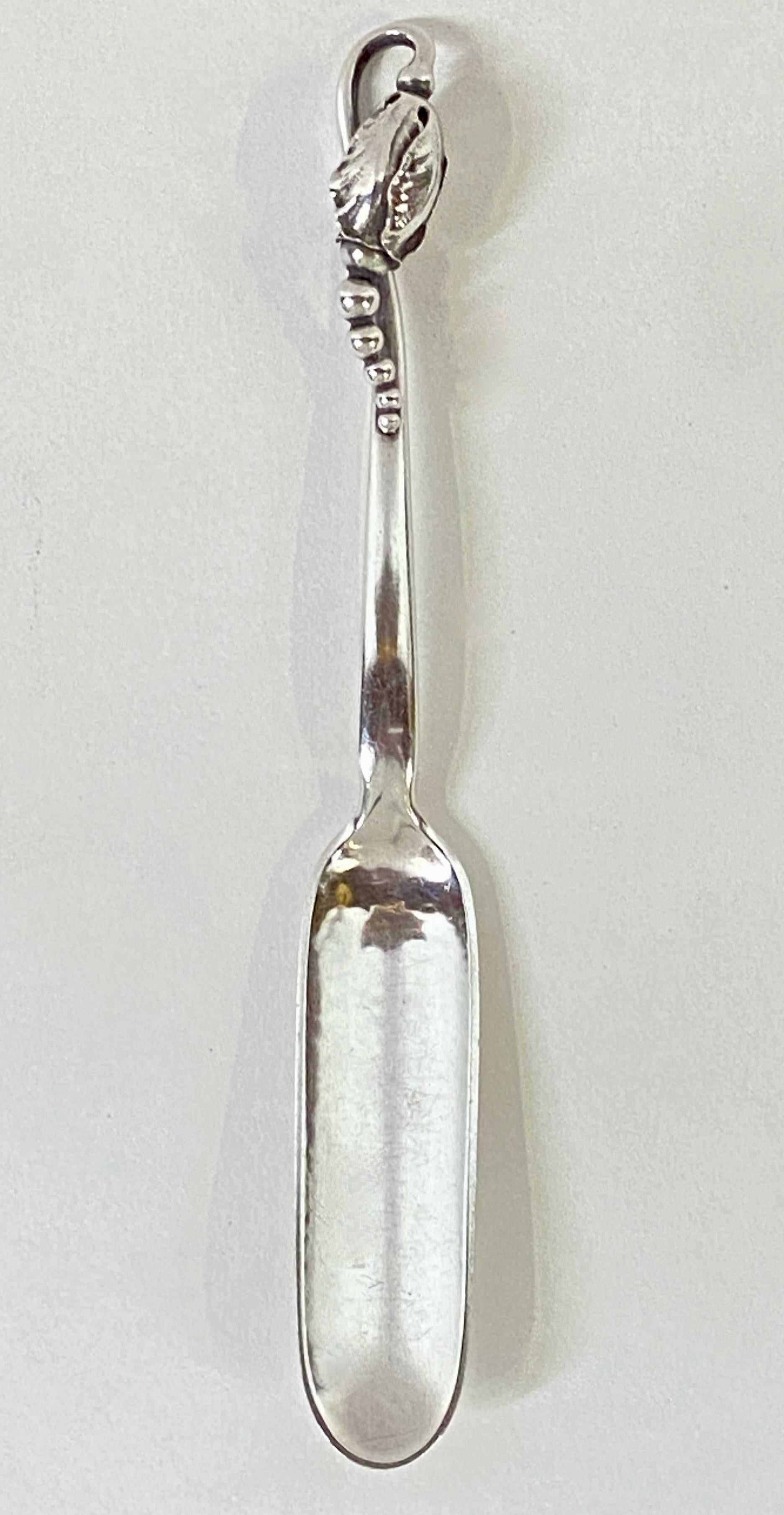 Una paletta per formaggio d'epoca in argento sterling martellato a mano con motivo Blossom di Georg Jensen.
Con marchio di garanzia, risale al 1933-1944. In ottime condizioni.

Disegnato nel 1905 da Georg Jensen, il delicato bocciolo Blossom fu
