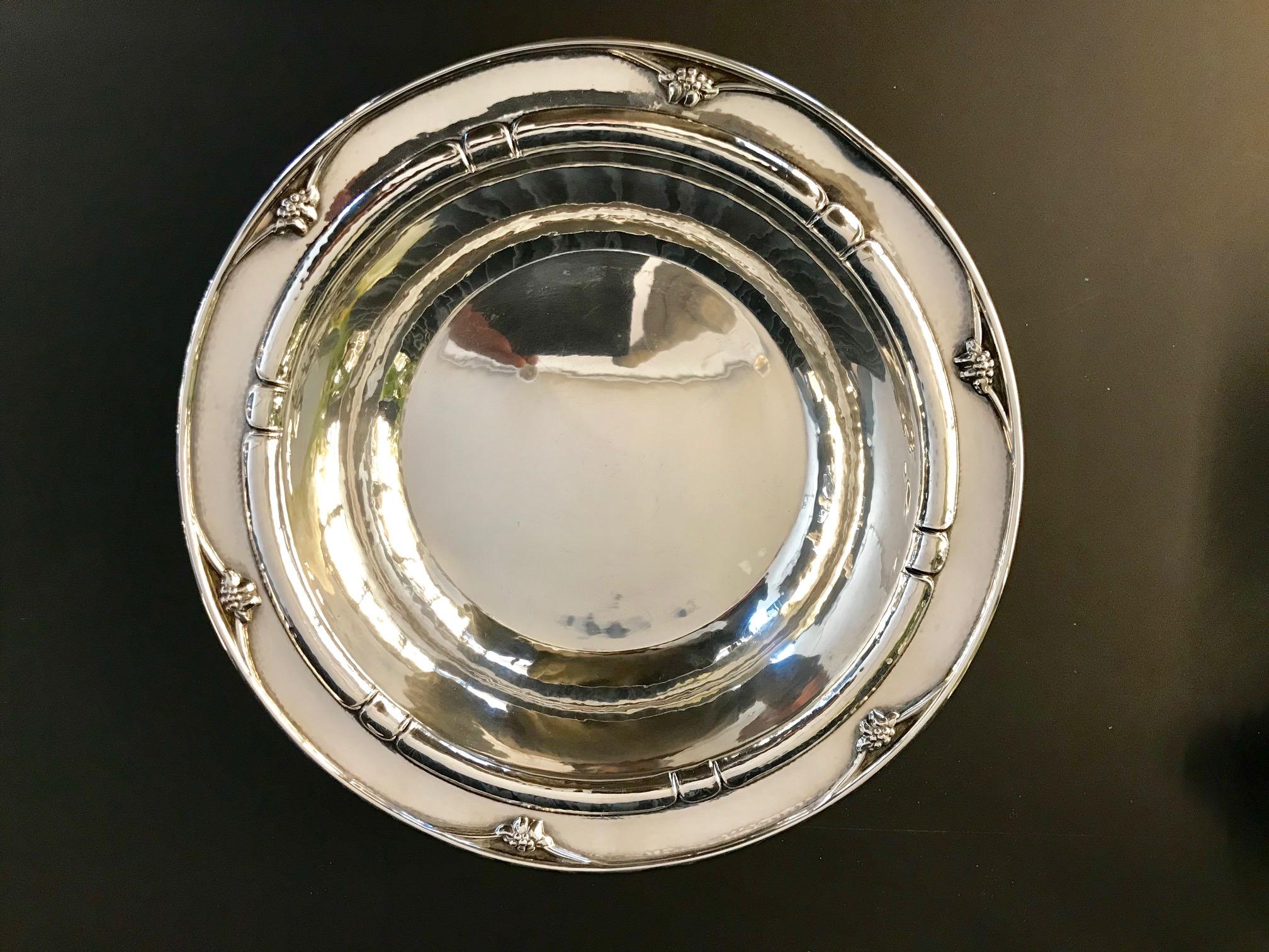This is a sterling silver Georg Jensen bowl with stylistic berry decorations on the rim, design #271D by Georg Jensen.

Measures: 2½” in height and 10 9/16? in diameter at the rim (6.4cm, 26.8cm).

Vintage Georg Jensen hallmarks from 1925-1932.