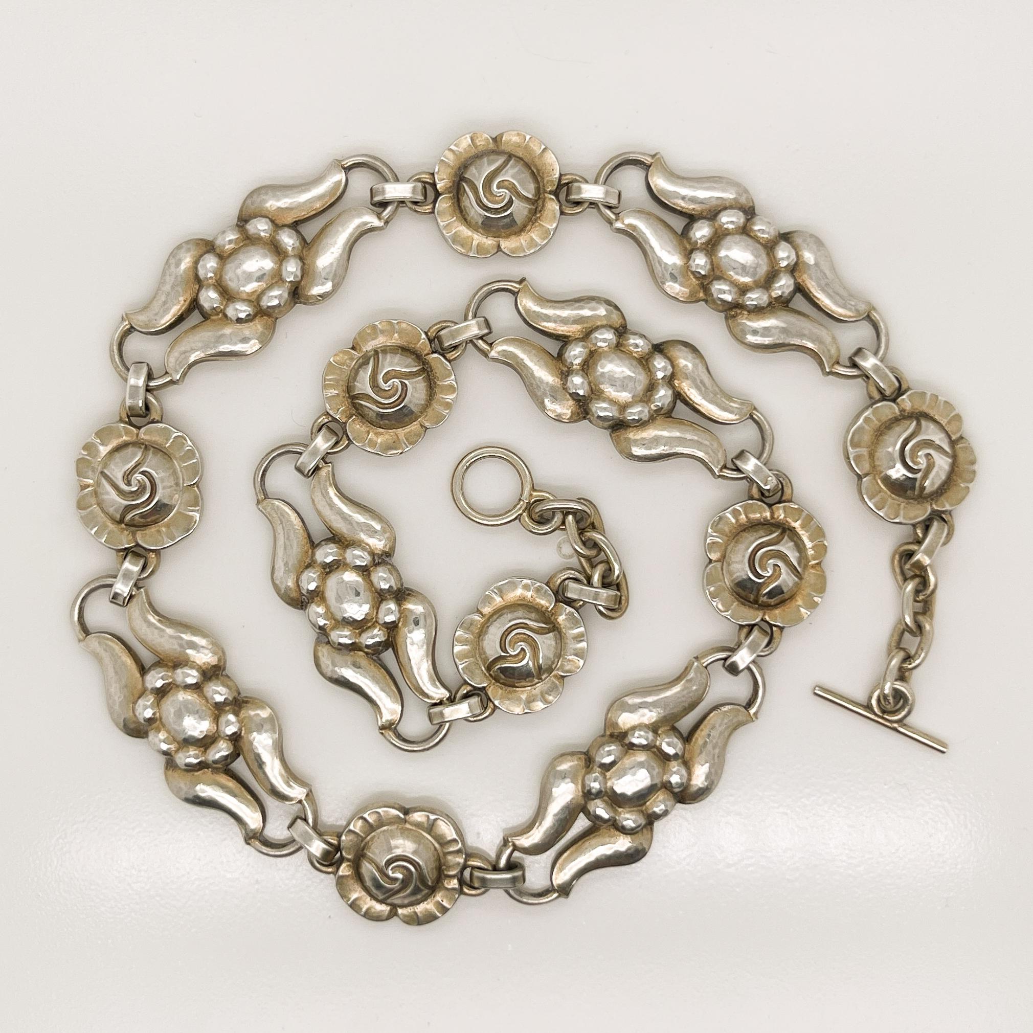 A very fine Georg Jensen necklace in sterling silver.

Model No. 10.

With alternating rose and stylized floral links, traces of its original gilding, and a toggle clasp.

Designed by Georg Jensen and bearing an old GI mark.

At approximately 14 1/2
