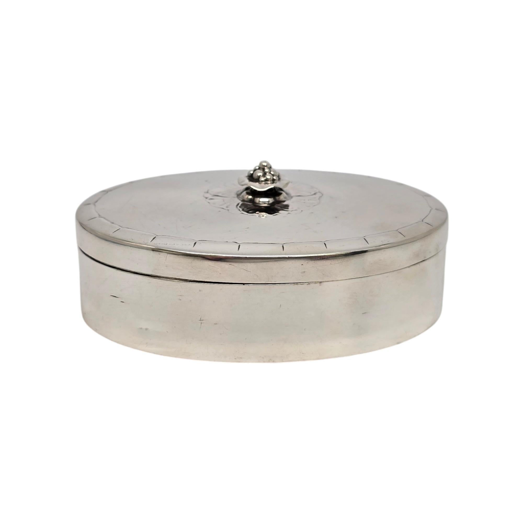 Vintage Georg Jensen Dänemark Sterlingsilber ovale Dose, Muster #79AB.

Ohne Monogramm oder Gravur.

Dieses schöne kleine ovale Kästchen kann für Schmuck, Kleinigkeiten oder alles andere verwendet werden. Der Deckel wird von einer kleinen Blume