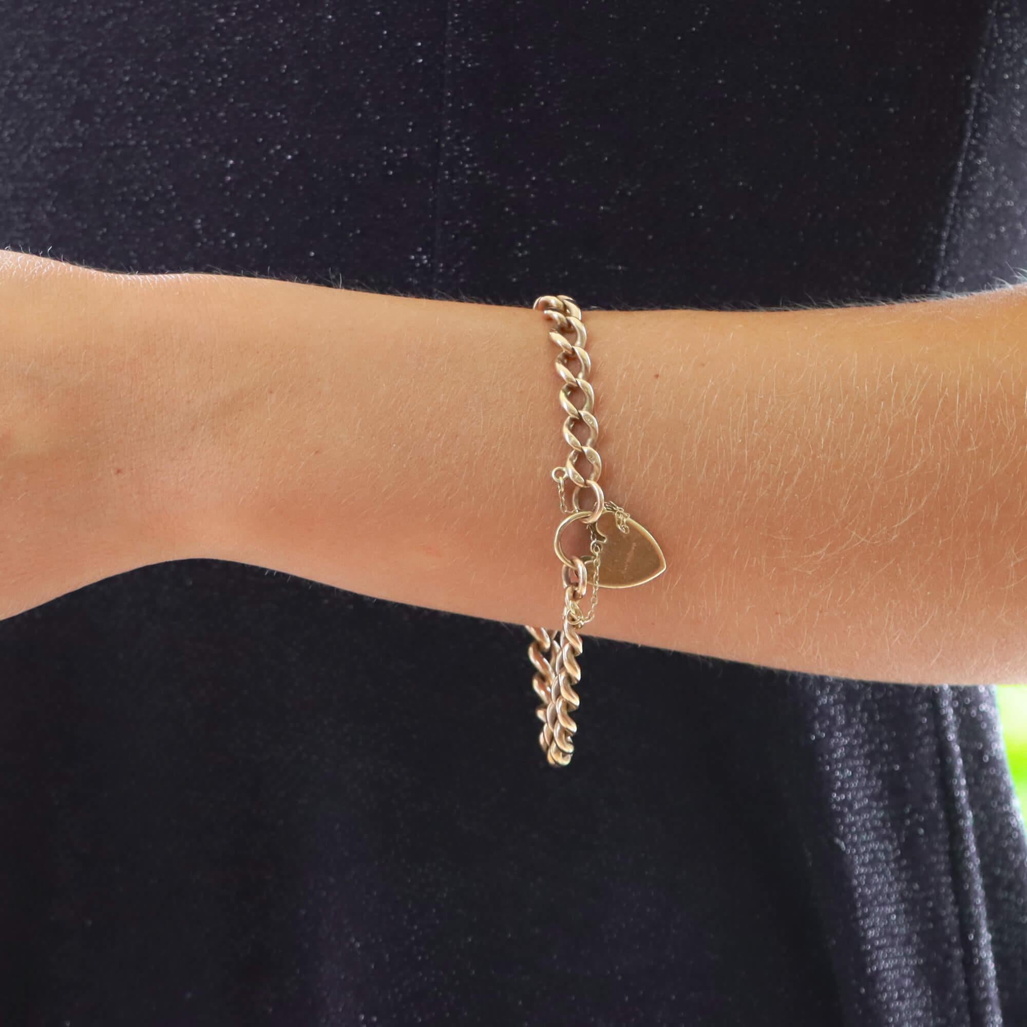 A classic vintage flat curb heart lock charm bracelet in solid 9k rose gold, signed Georg Jensen.

The bracelet is composed of 32 solid 9k rose gold links. The chain bracelet is fastened with a vintage padlock heart clasp which has been hand
