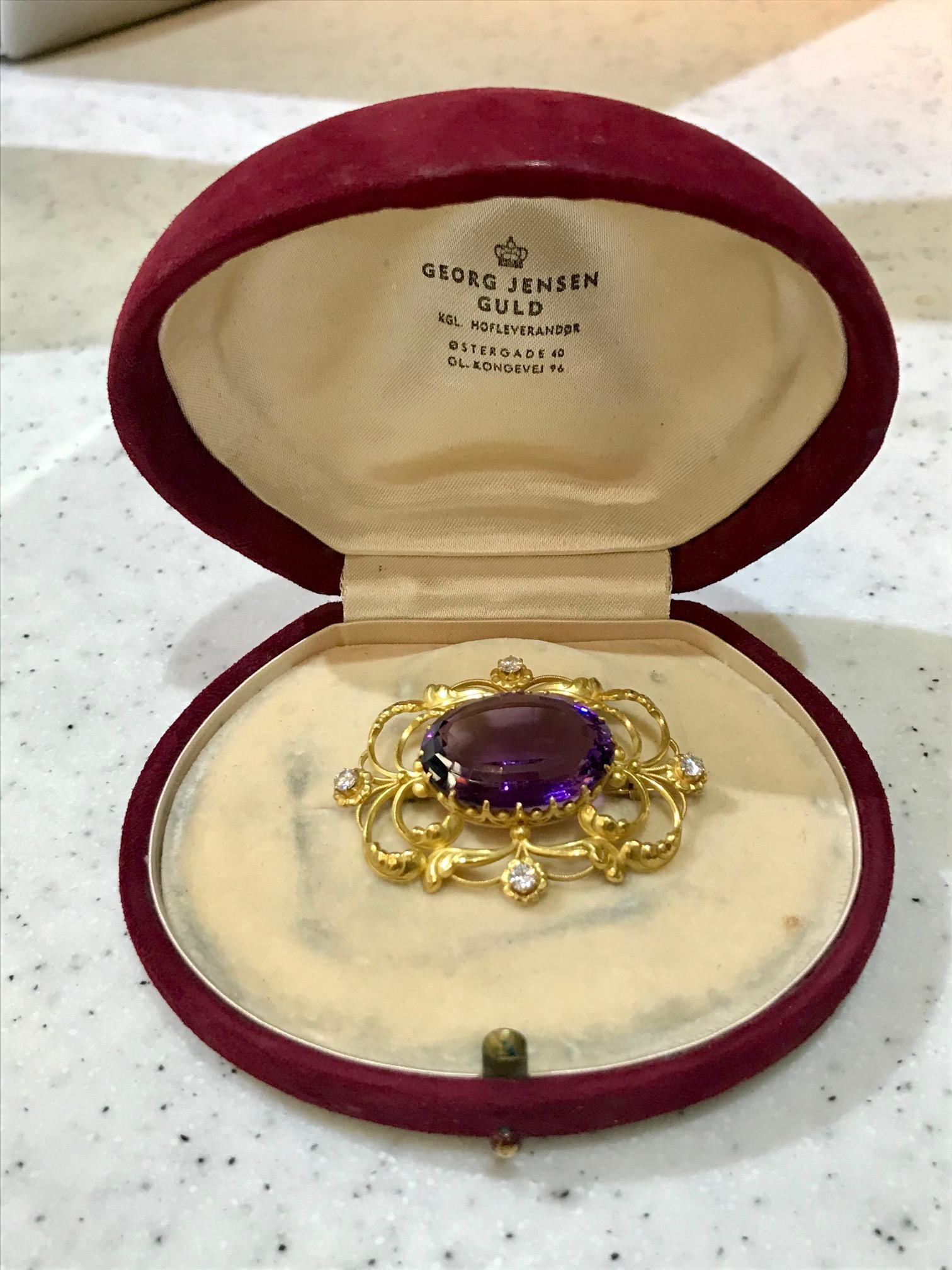 This is an 18kt gold Georg Jensen Art Nouveau brooch with a large oval cut amethyst stone and four small diamonds, design #21 by Georg Jensen. The diamonds are VS2.SI1 and are combined approximately 0.25ct.

The brooch measures 2
