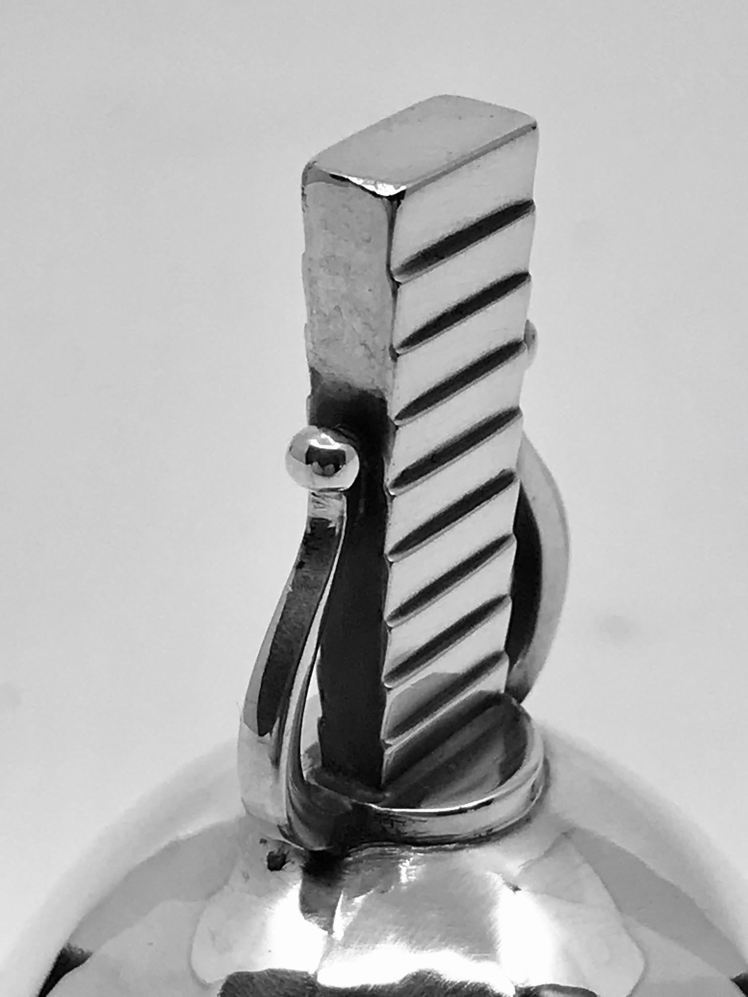 Sterling silver Georg Jensen table bell, design #247 by Oscar Gundlach-Pedersen, made to match his Parallel flatware pattern from 1931.

Measures 2 7/8? in height and has a diameter of 1 5/8? (7.3cm, 4cm).

Vintage Georg Jensen hallmark from