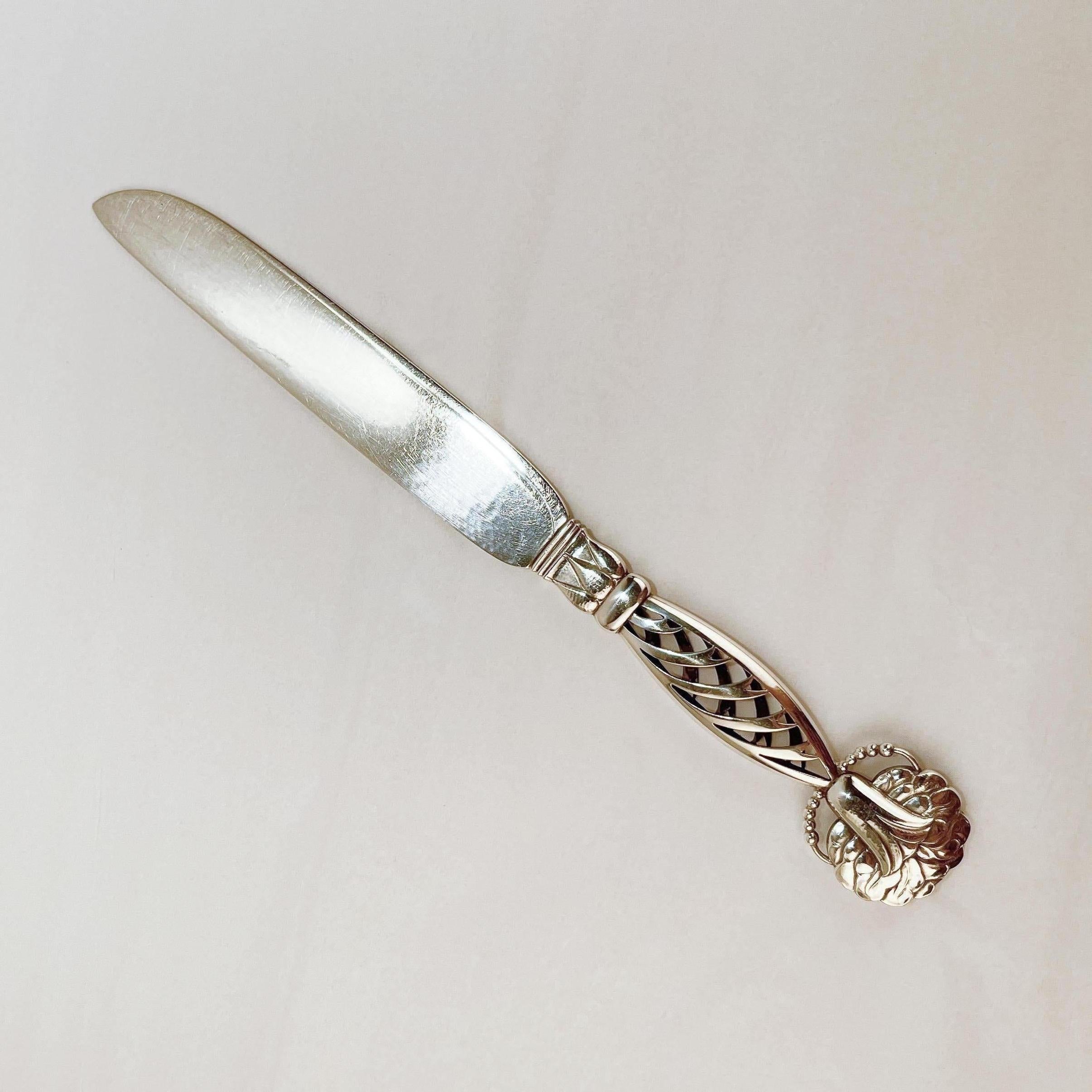 A fine cake knife by Georg Jensen.

Design no. 83 with an ornamental handle that has an openwork grip with a stylized flower.

The blade is hand-hammered.

Simply a terrific piece from a top-shelf silversmith!

Date:
20th Century

Overall