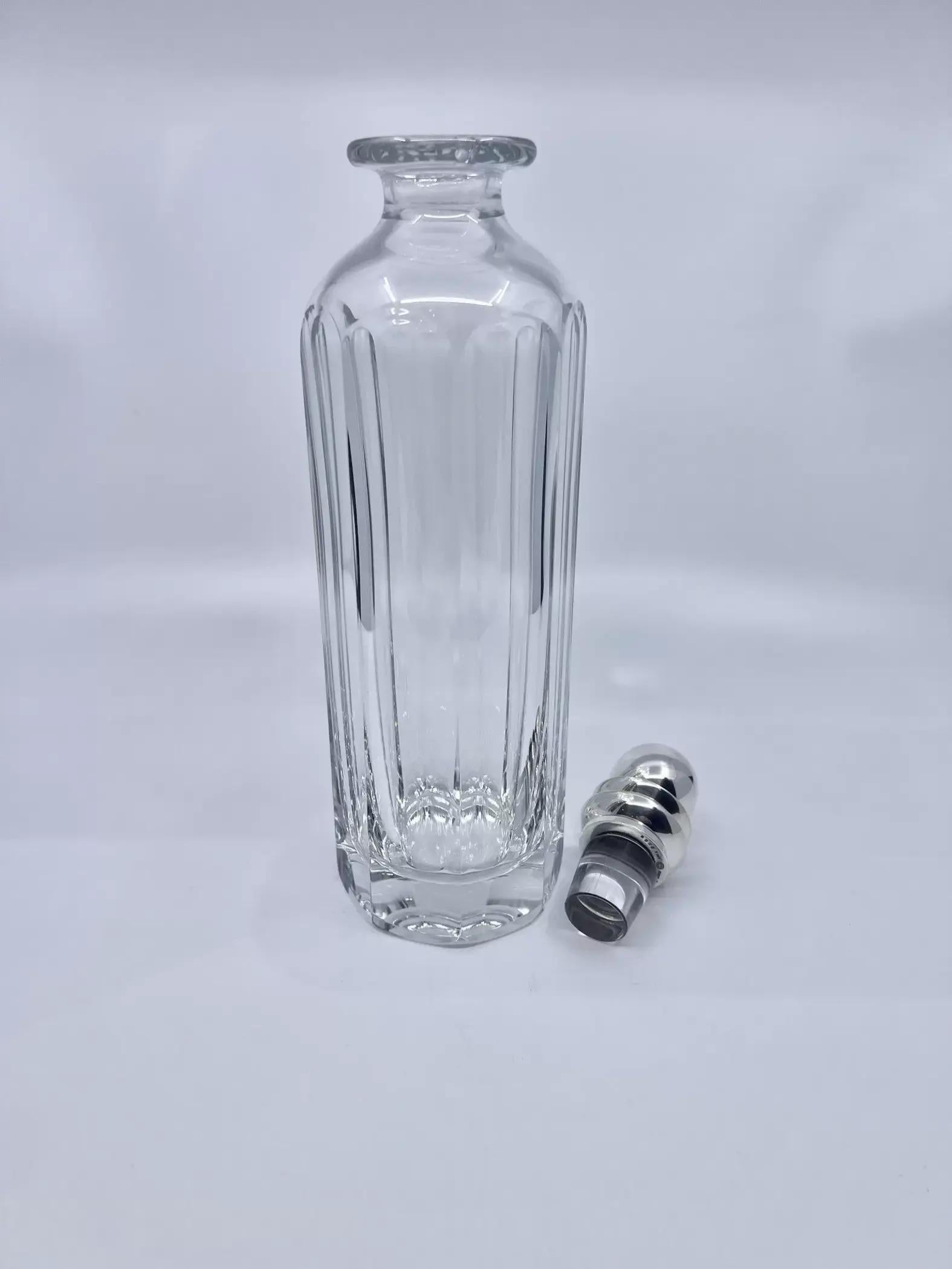 A vintage Baccarat crystal decanter with sterling silver Georg Jensen stopper in the Pyramid pattern, design #206 by Harald Nielsen from circa 1935. There is a minor chip on the inner side of the rim, which is not viable when the stopper is