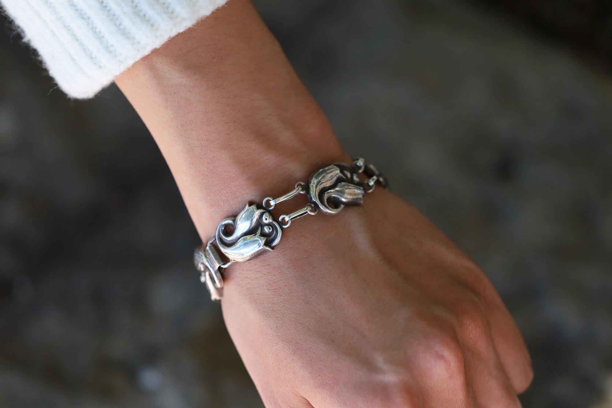 A classic Danish designer, Georg Jensen's jewelry has been coveted by collectors of Art Nouveau motifs for over a century. The iconic tulip design sterling silver bracelet from the La Paglia collection, number 100. The Georg Jensen company has
