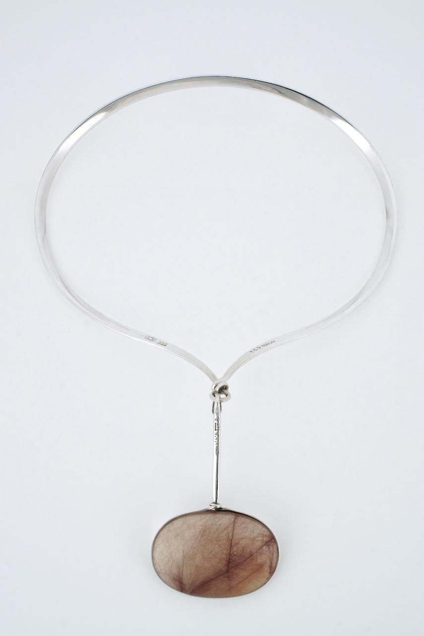 A vintage solid silver and oval rust brown rutilated quartz pendant neck ring - Torun for Georg Jensen - a beautiful oval double sided cabochon of rutilated smoky quartz with strong rust brown rutilations wrapped with wire and suspended crossways