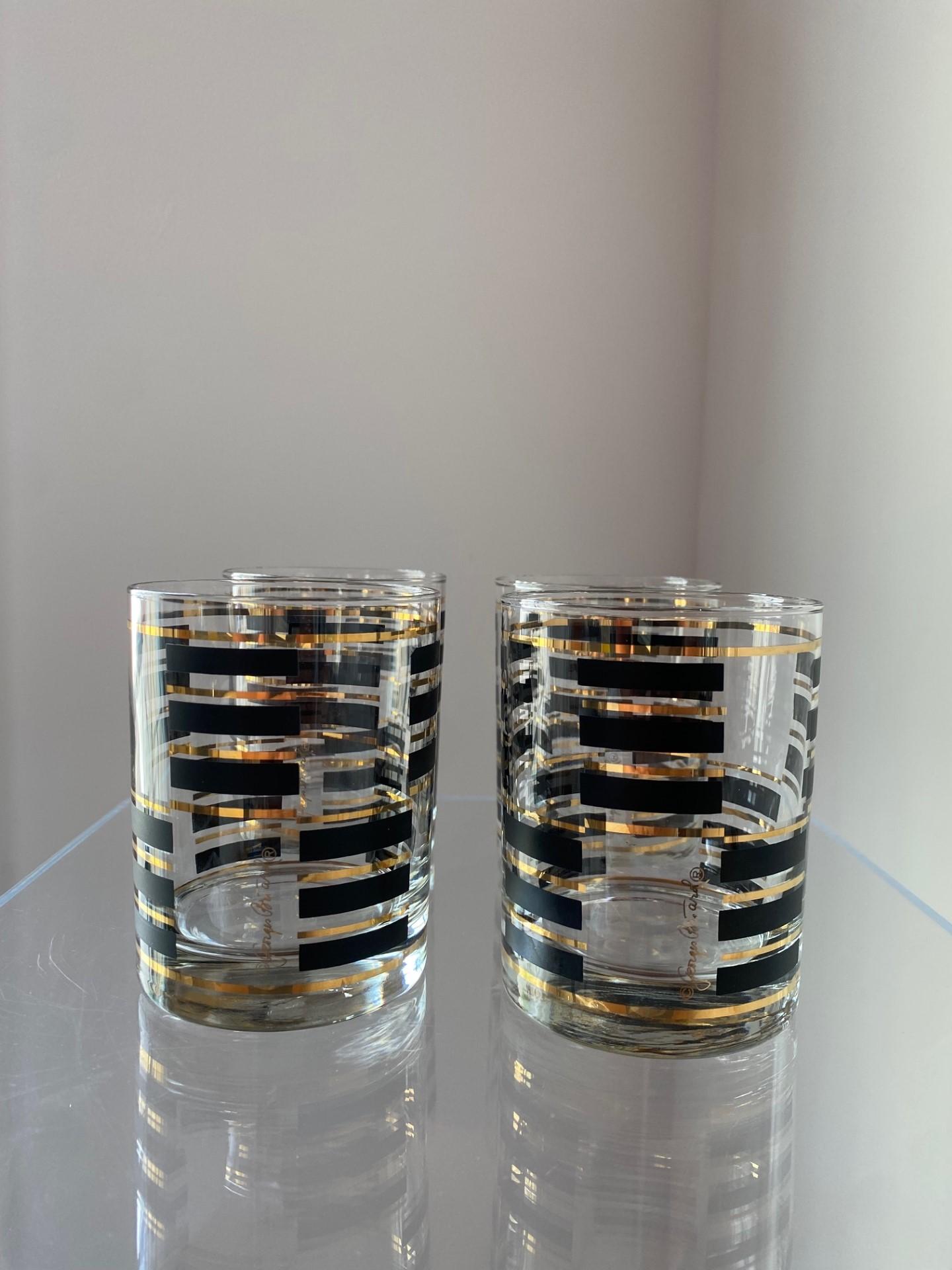 Chic, modernist and beautiful mid-century set of glasses.  Barware has never been more glamorous.  This set from George Briard features 22-karat gold and black modernist lines envolving each glass. The design in each glass is evocative of the era,