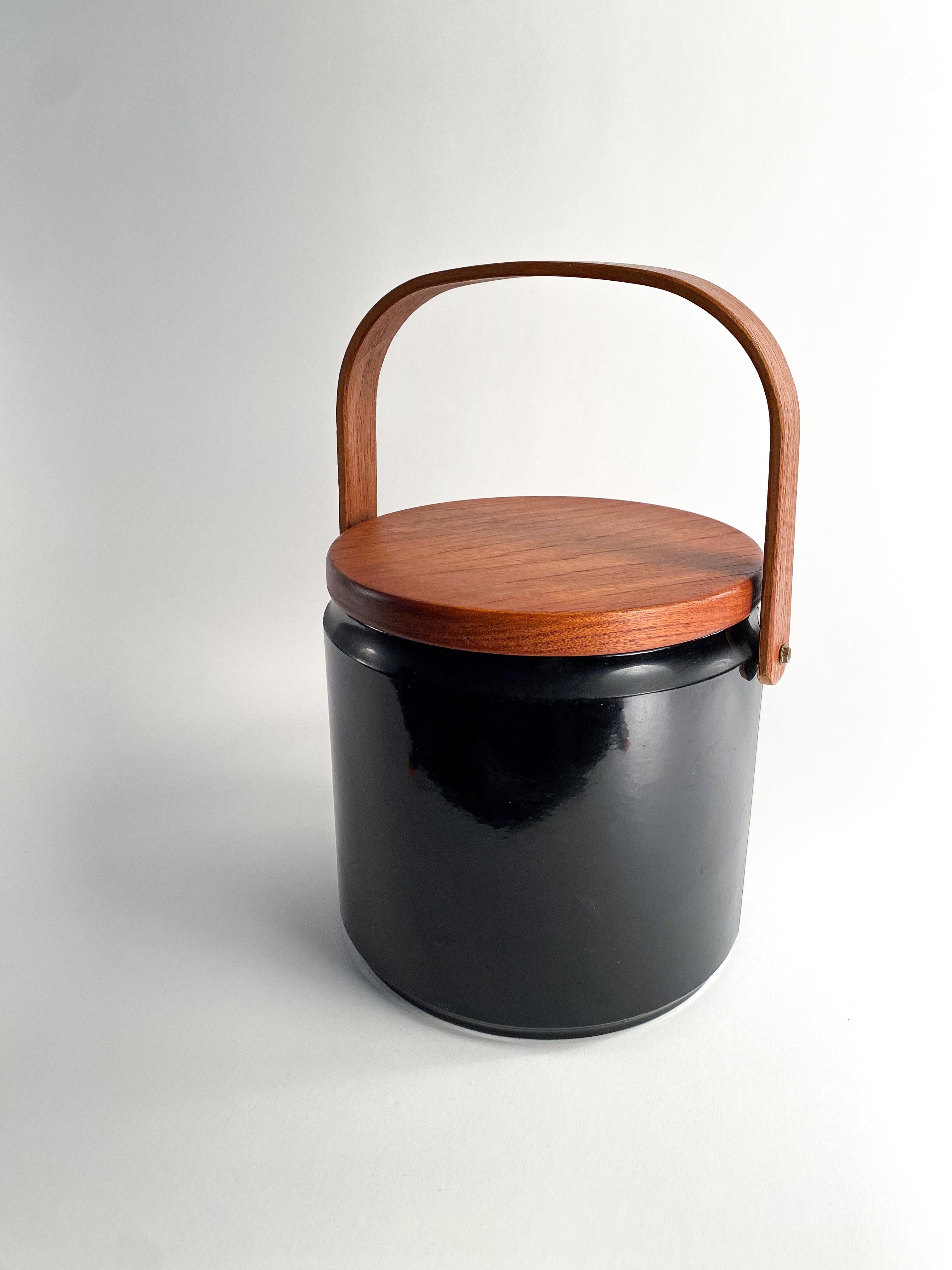 Great looking vintage black ice bucket with teak lid and Bent teak handle.  will go well with any mid century or contemporary bar set.