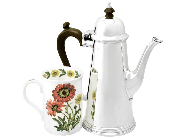 A fine and impressive vintage Elizabeth II English sterling silver coffee pot in the George I style; an addition to our silver teaware collection.

This fine vintage Elizabeth II sterling silver coffee pot has a plain tapering cylindrical form to