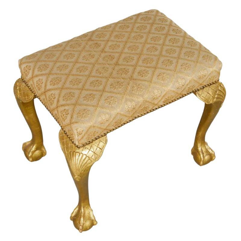 A vintage George II style giltwood carved stool.  The elegant stool has an upholstered seat of gold trellis floral design with nail head trim.  The beautiful legs are cabriole shaped with shell and trellis motif at the knee and claw and ball feet.  