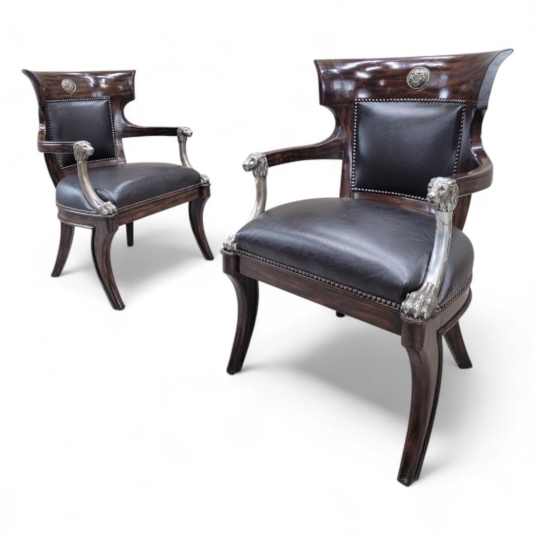 Vintage George IV English Regency Style Schwarzes Leder Stühle mit Metall Löwenkopf Arme und Säbel Beine - Paar 

Dieses auffällige Paar englischer Stühle im Regency-Stil fängt die Opulenz und Raffinesse der Ära George IV. wunderbar ein. Jeder Stuhl