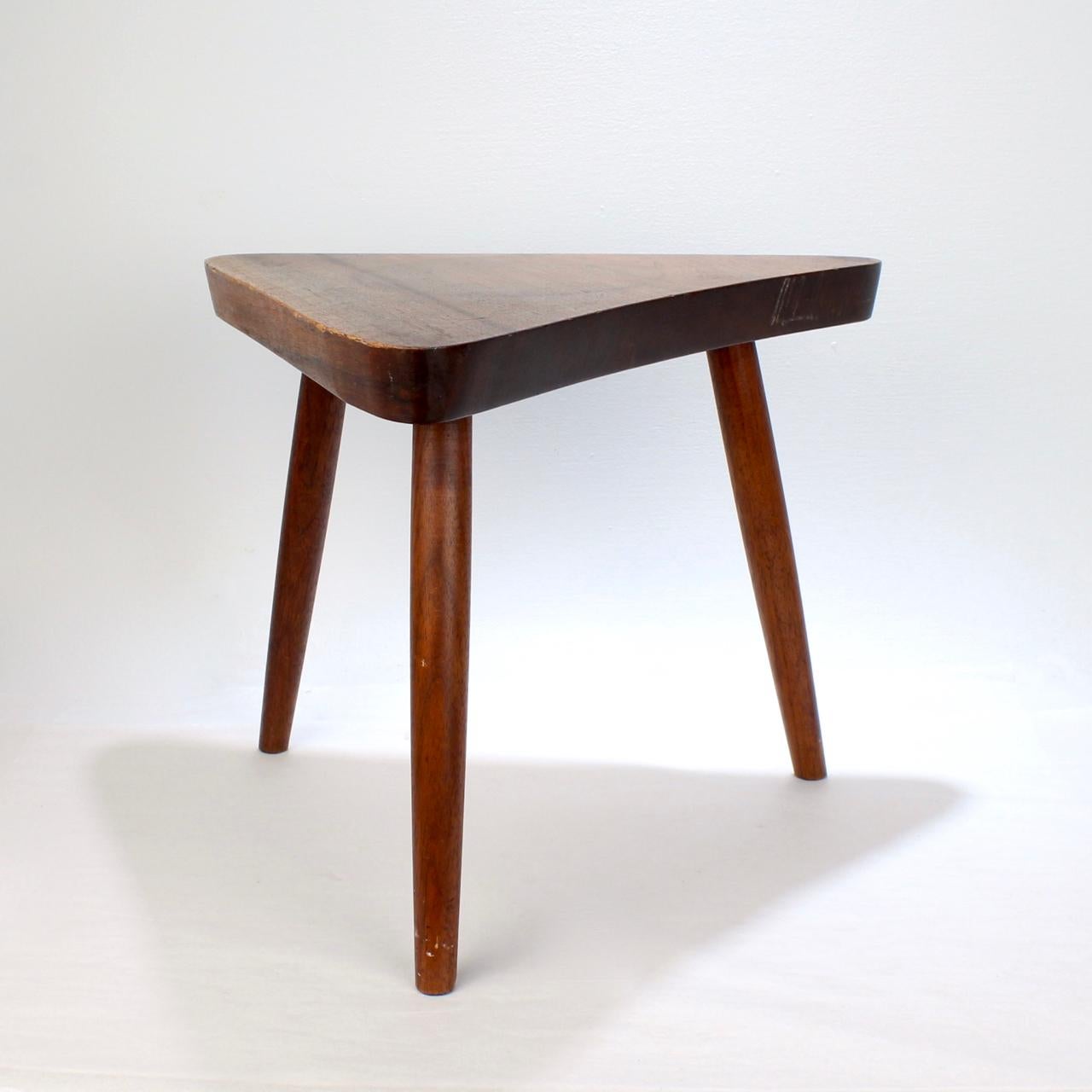 A wonderful walnut plank stool by George Nakashima.

With faint pencil scoring marks to the underside and original glue to the turned legs.

A wonderful fresh discovery from a small Bucks County, PA estate (that was clearly used as a plant stand