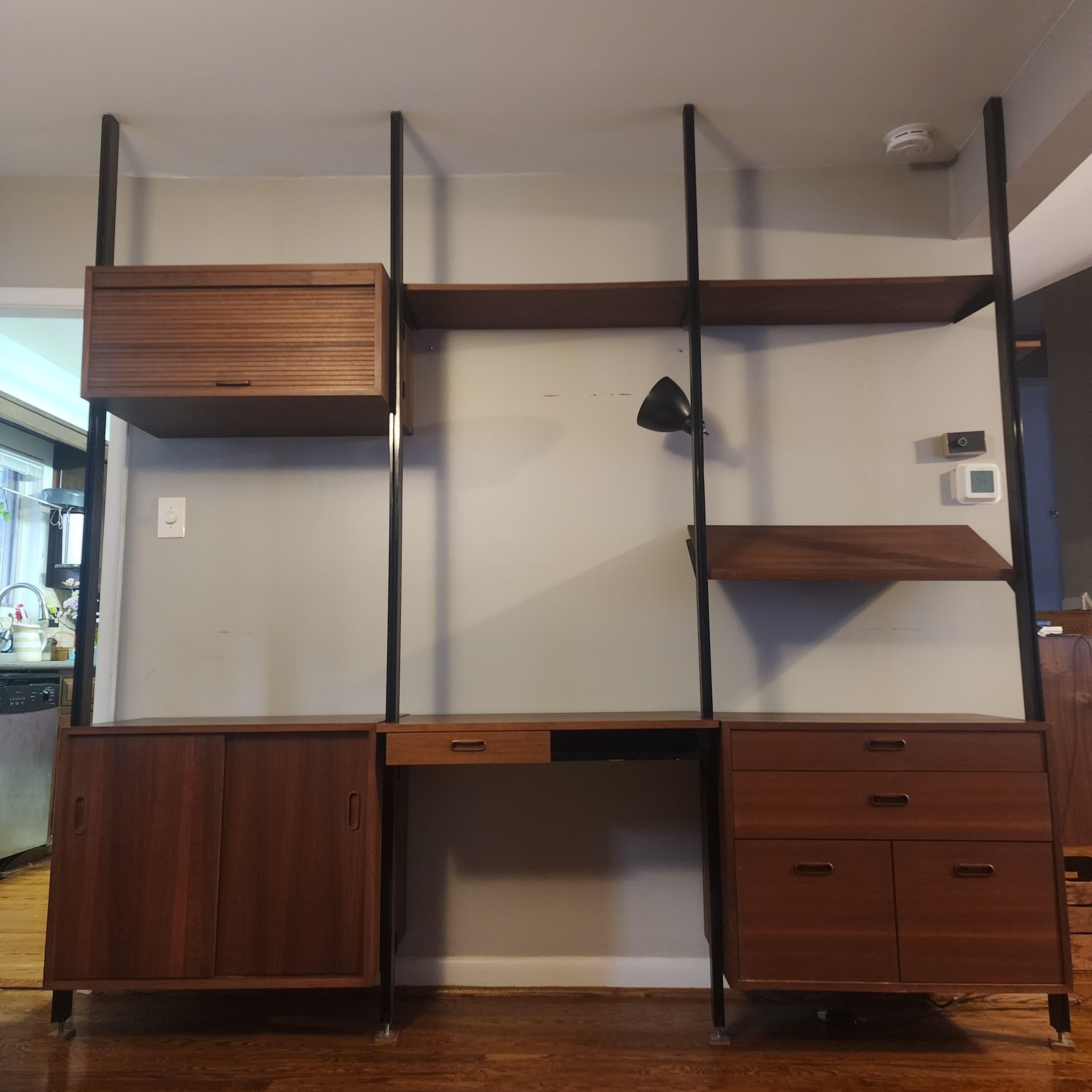 Beautiful walnut and aluminum ceiling to floor Omni wall unit by George Nelson.  features walnut faced aluminum uprights with one light, tambour cabinet, sliding door cabinet,  desk with drawer, drawer cabinets with 2 drawers for files, a magazine