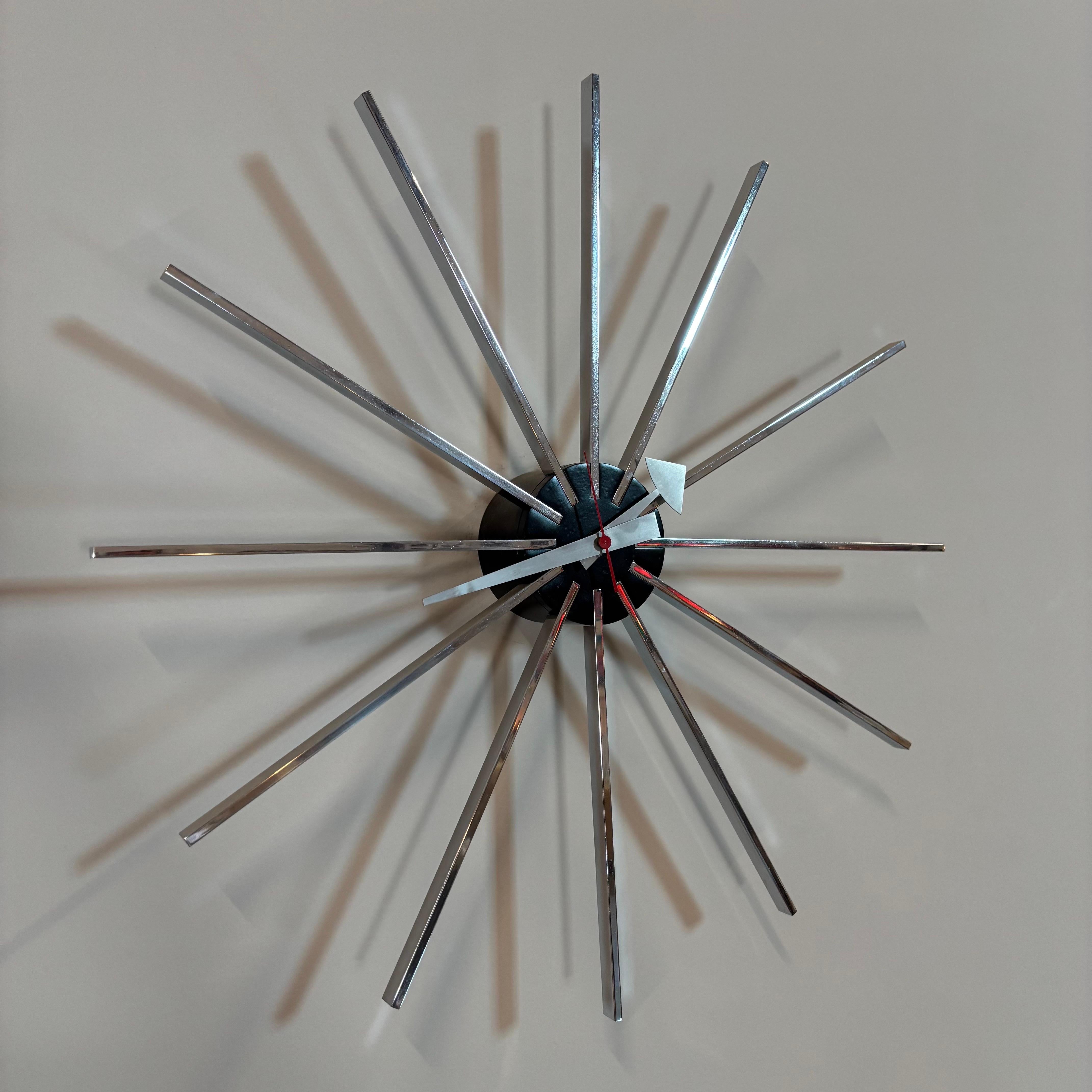 Mid-Century Modern wall clock designed by George Nelson & Associates for Howard Miller Clock Company. Produced in 1955, this piece was named the 'Spoke' clock model no. 2227. Operates with one AA battery. 