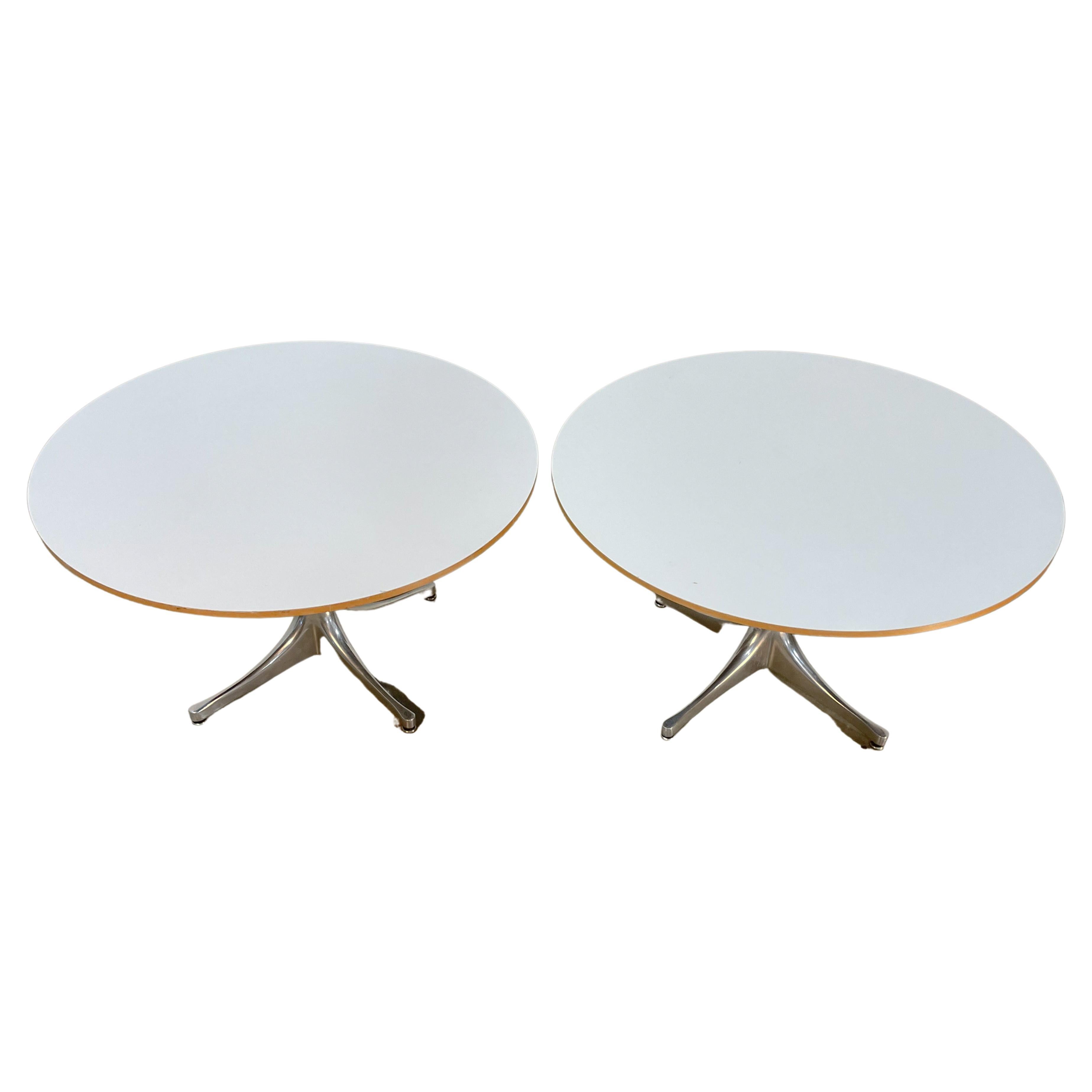 Minimalist chrome pedestal tables with white Formica tops designed by George Nelson for Herman Miller. The cast aluminum legs have a sculptural quality and give the tops a floating effect. Made in the 1970s, these vintage tables are in very good