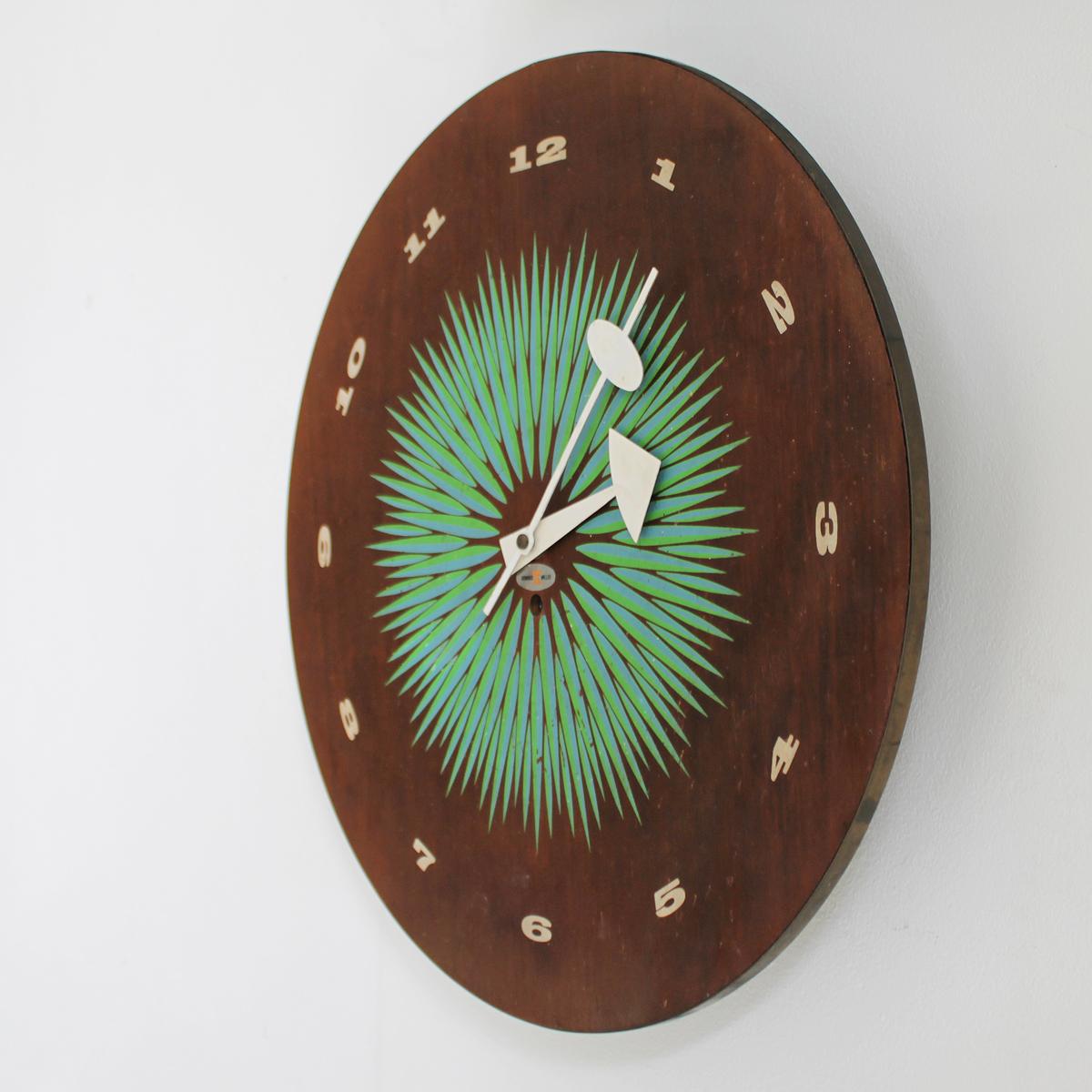 Rare original wall clock Number 2236. Design by George Nelson and Associates for Howard Miller Clock Company, Zeeland Michigan, 1957. 
Walnut dial with silk-screened pattern in green and blue. White numerals and hands. Mechanical clock work with a